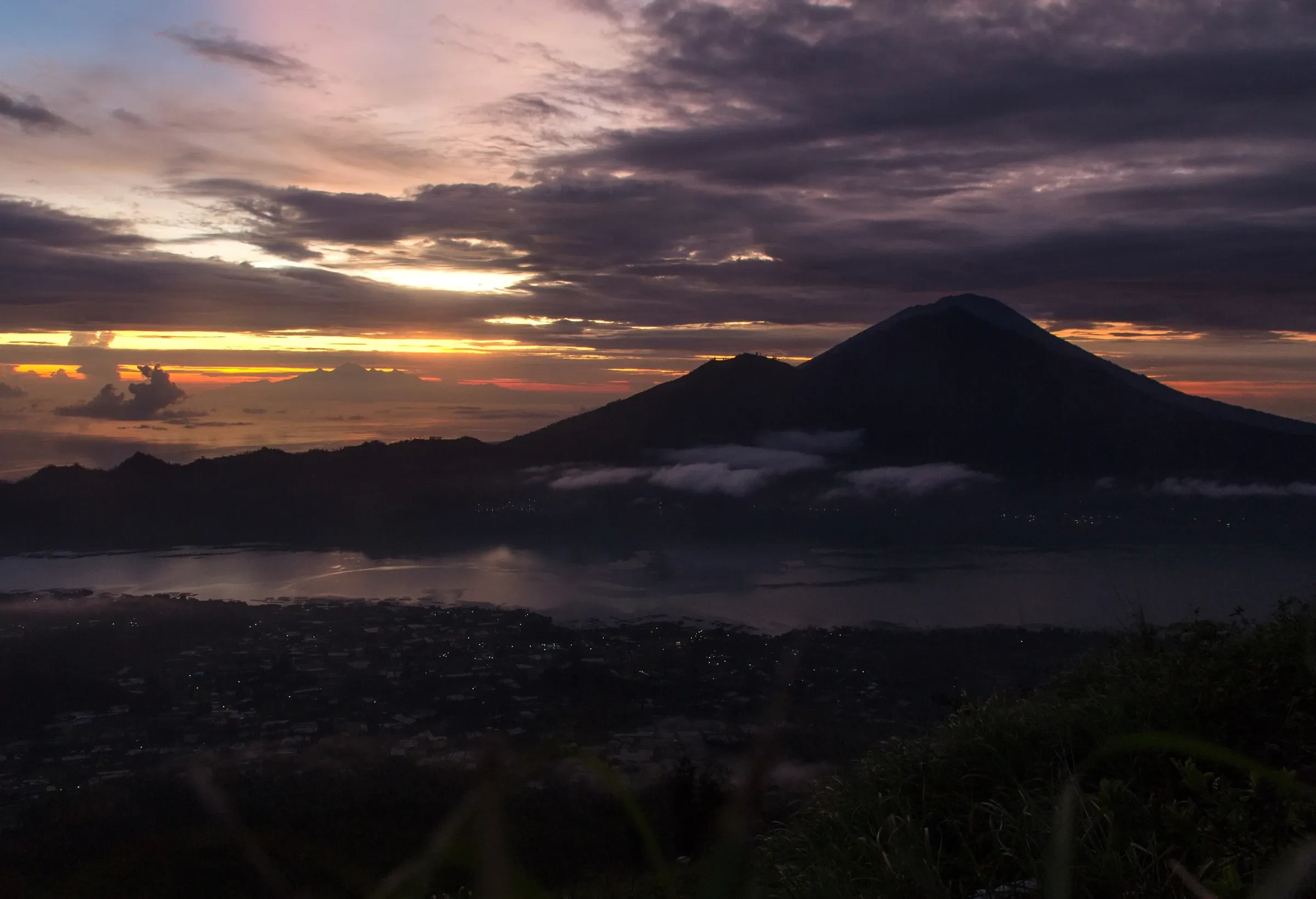 Sunrise over the Batur caldera with a volcano on the horizon