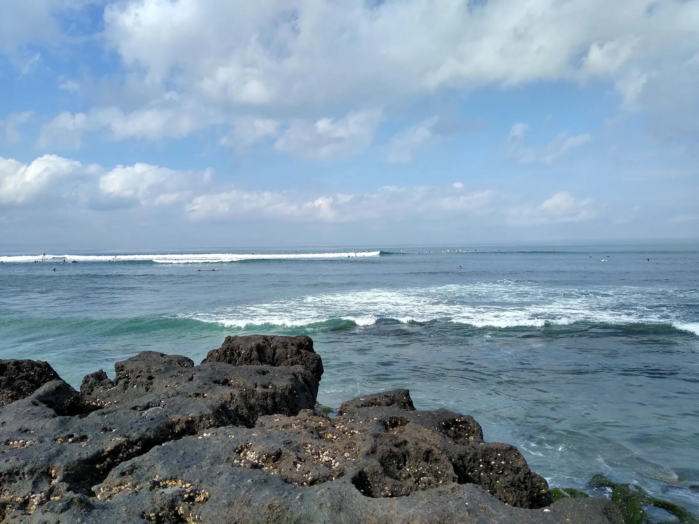Waves breaking over rocks on a Canggu beach