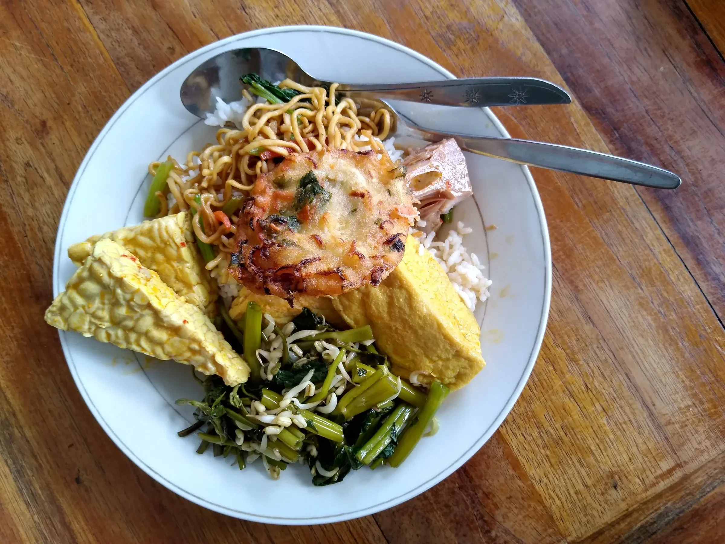 A plate of rice, noodles, tempeh and vegetables at a warung in Canggu, Bali