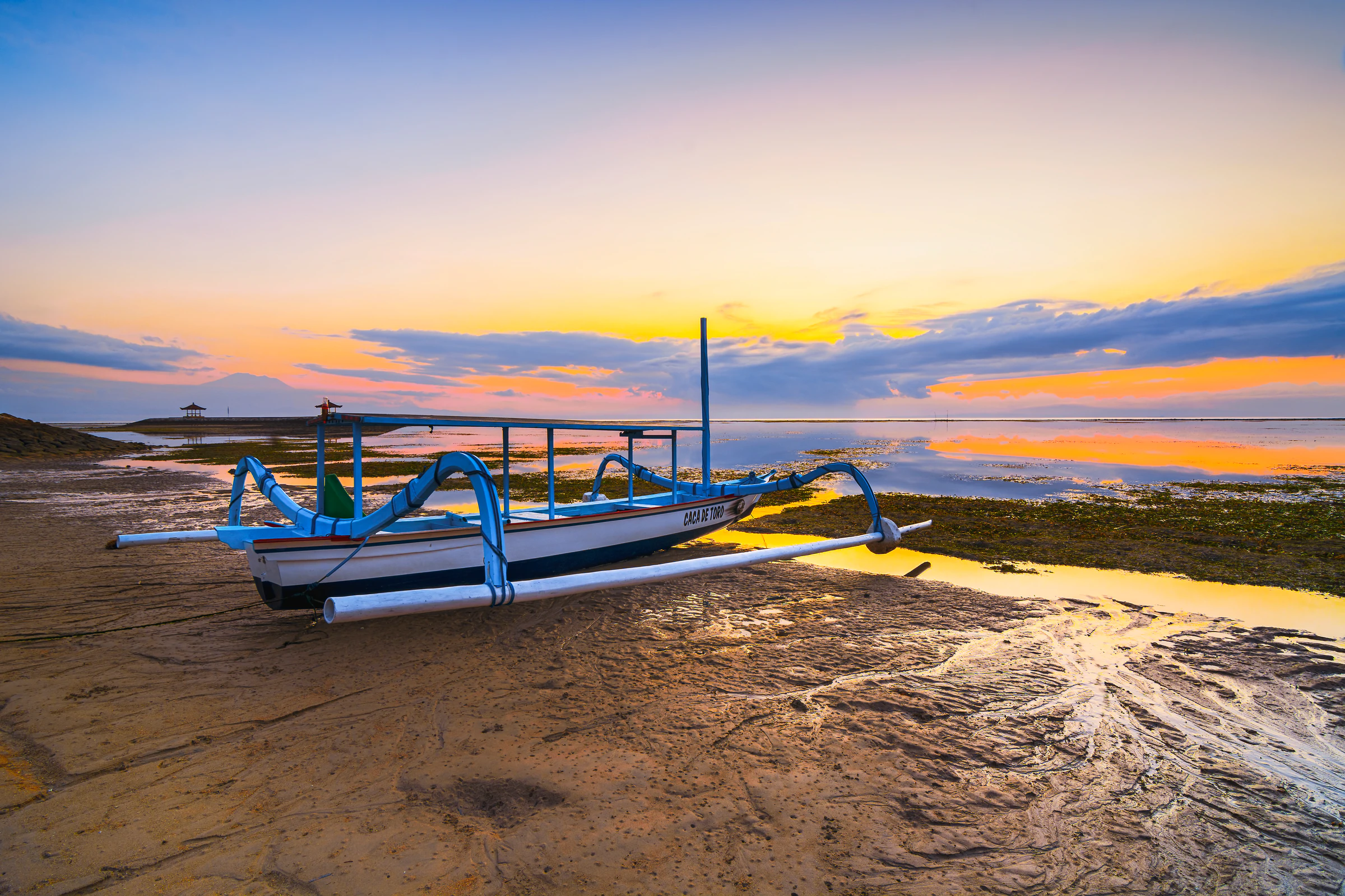 Traditional jukung fishing boats on Sanur beach at sunrise