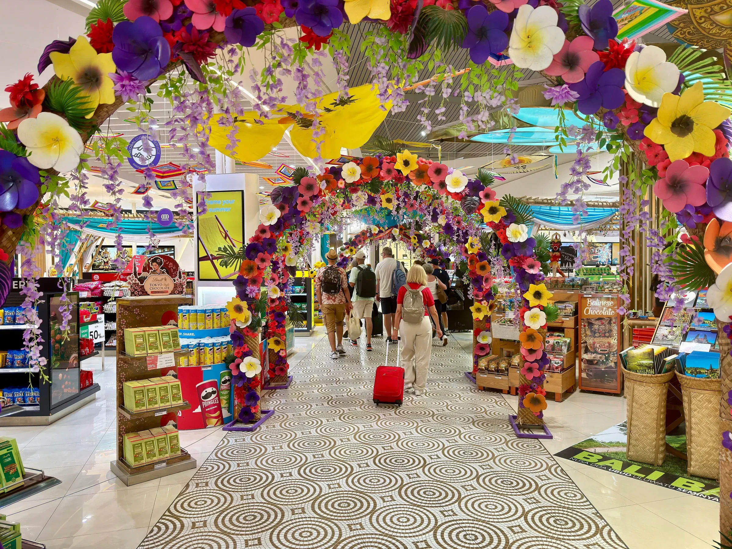 A flower-decked archway leading into the duty-free shops in the international terminal at Ngurah Rai airport