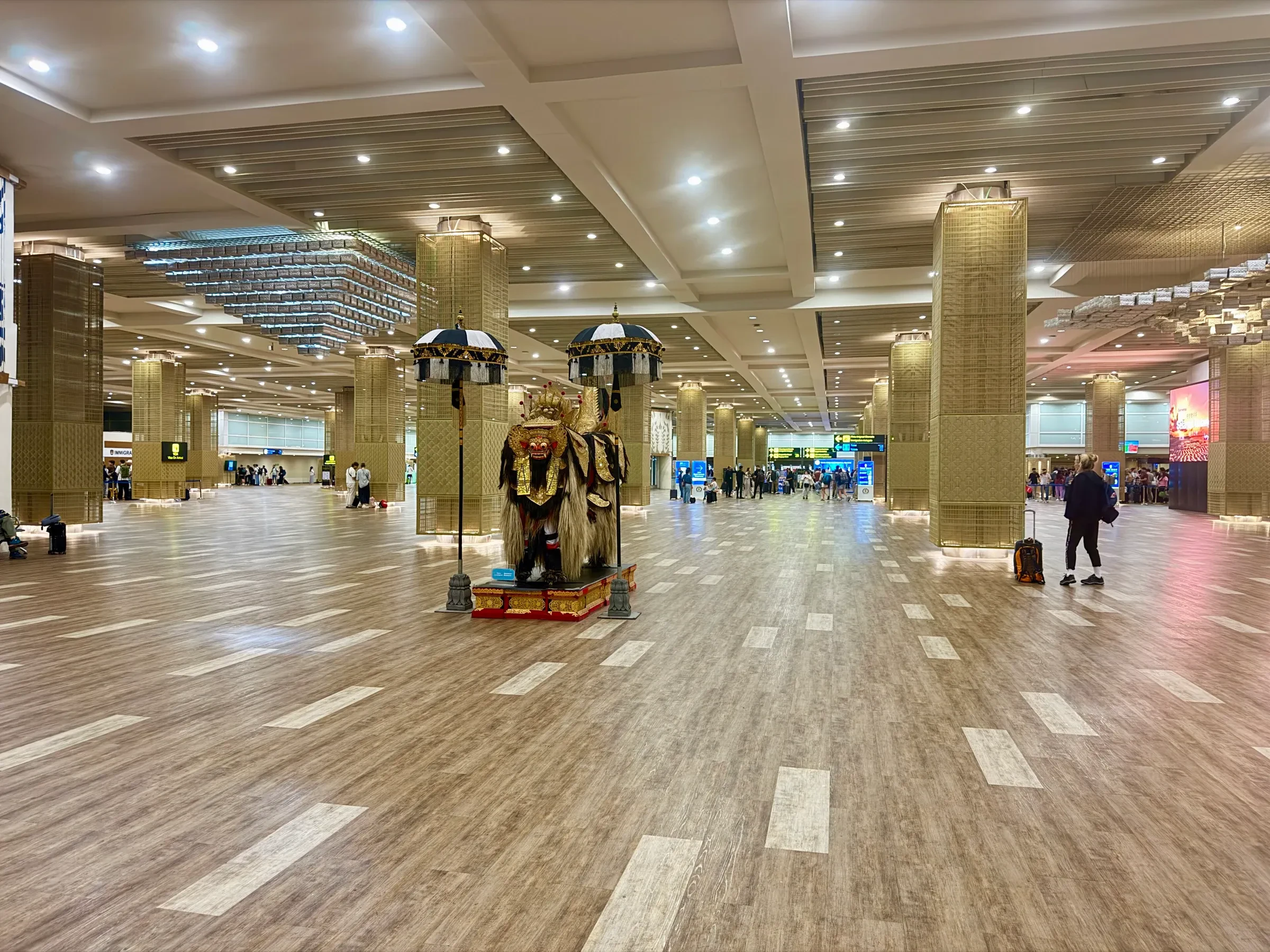 Inside the international terminal at Ngurah Rai airport, Bali, with a Balinese guardian statue in the hall