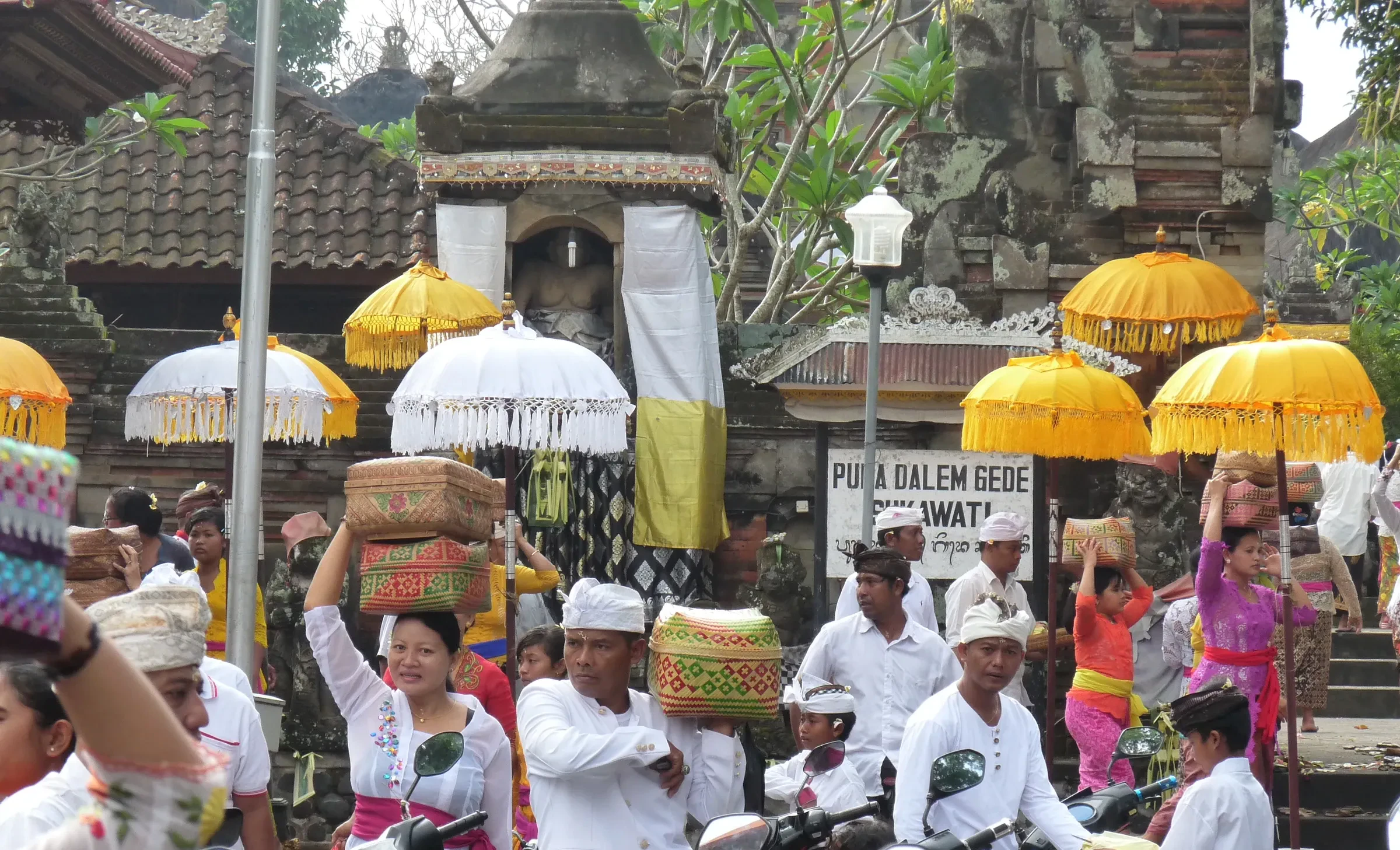 Families carrying offerings on their heads at a temple in Sukawati during Galungan