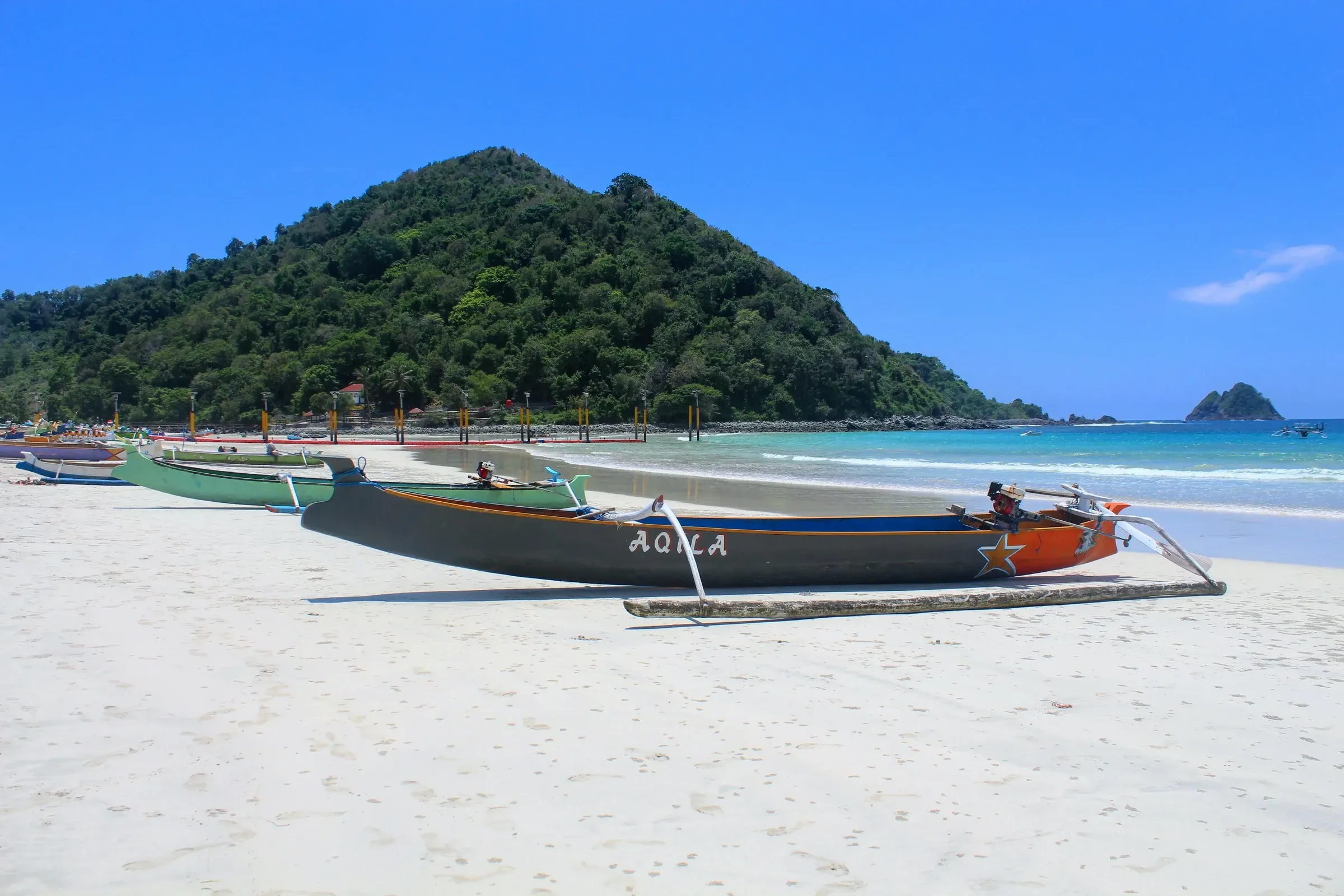 Painted fishing boats on the white sand of Selong Belanak beach on Lombok's south coast