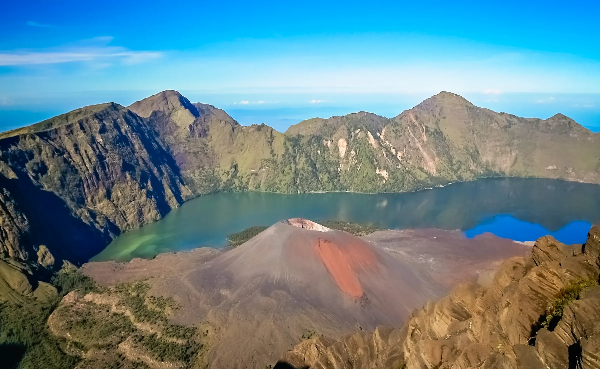 The turquoise crater lake inside Mount Rinjani's caldera, with a small cone rising beside it