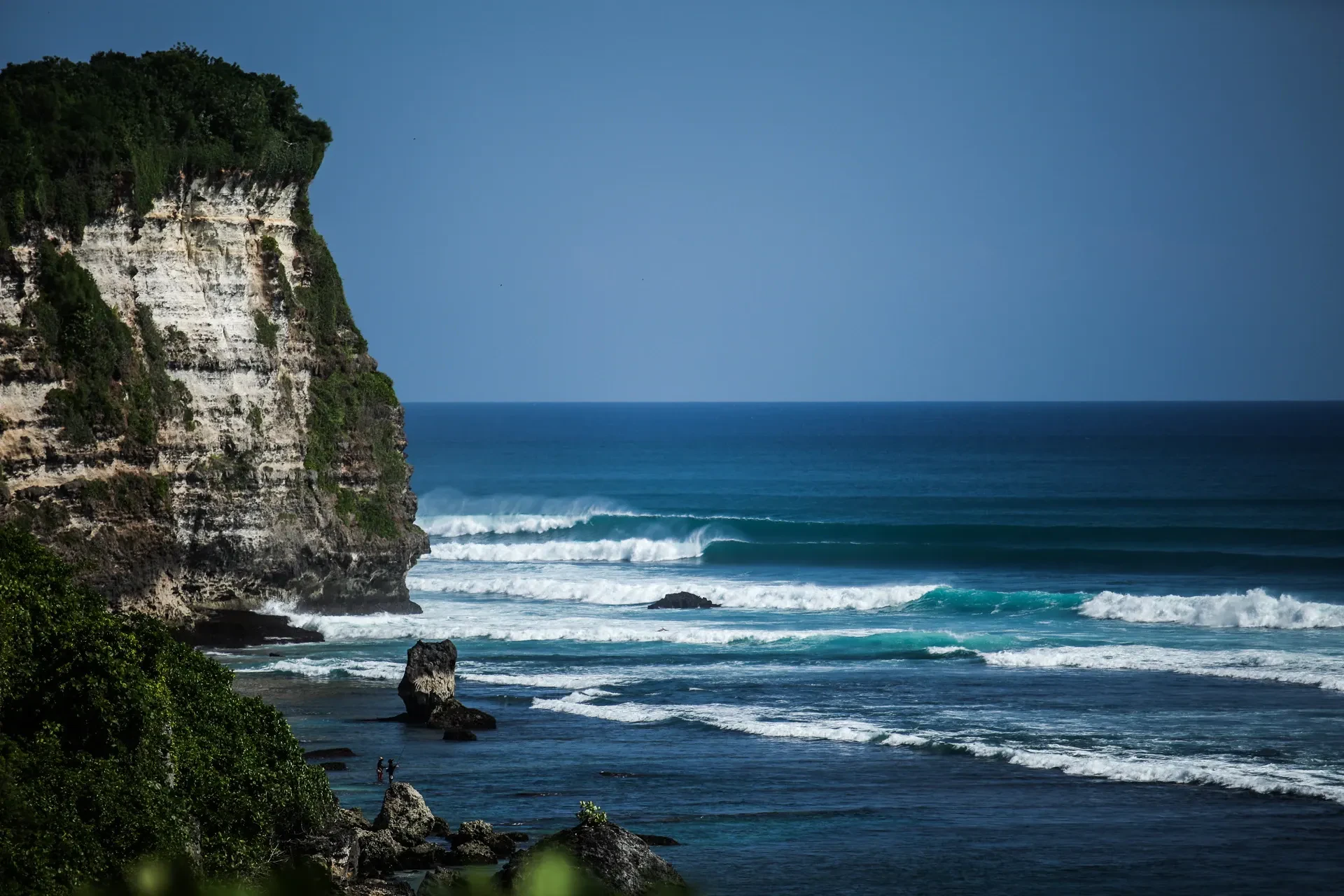 Waves peeling along a limestone cliff on Bali's Bukit peninsula near Uluwatu