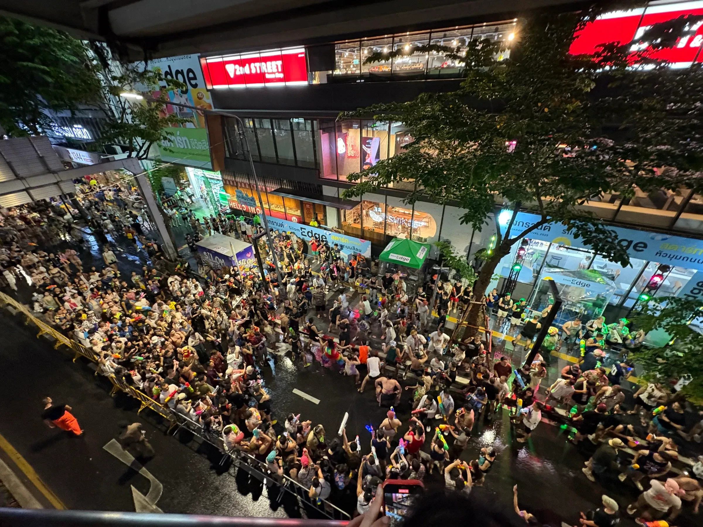 A crowd packing Si Lom Road in Bangkok during a Songkran water fight at night