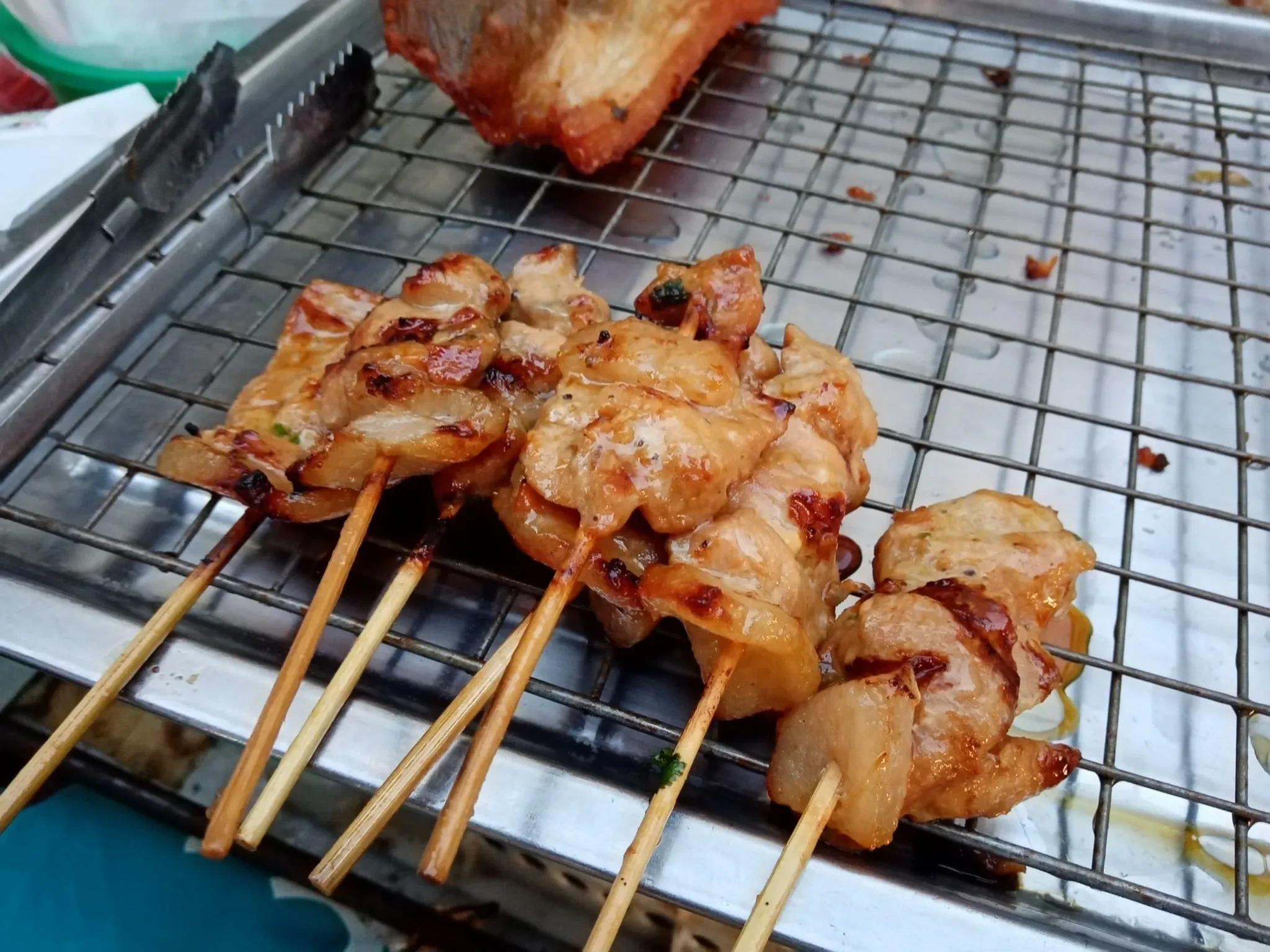 Mu ping, Thai grilled pork skewers, cooking on a grill rack