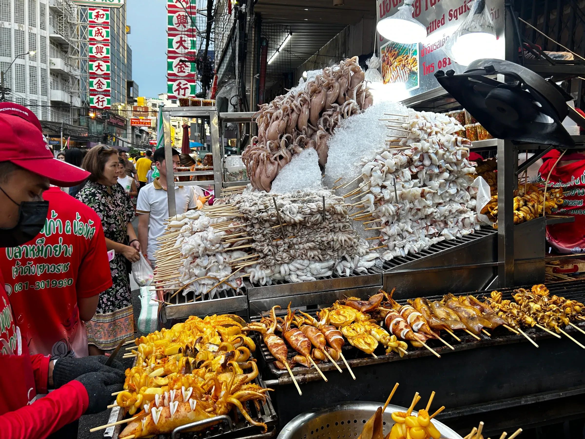 Skewers of cuttlefish and other grilled seafood at a street food stall in Bangkok's Chinatown