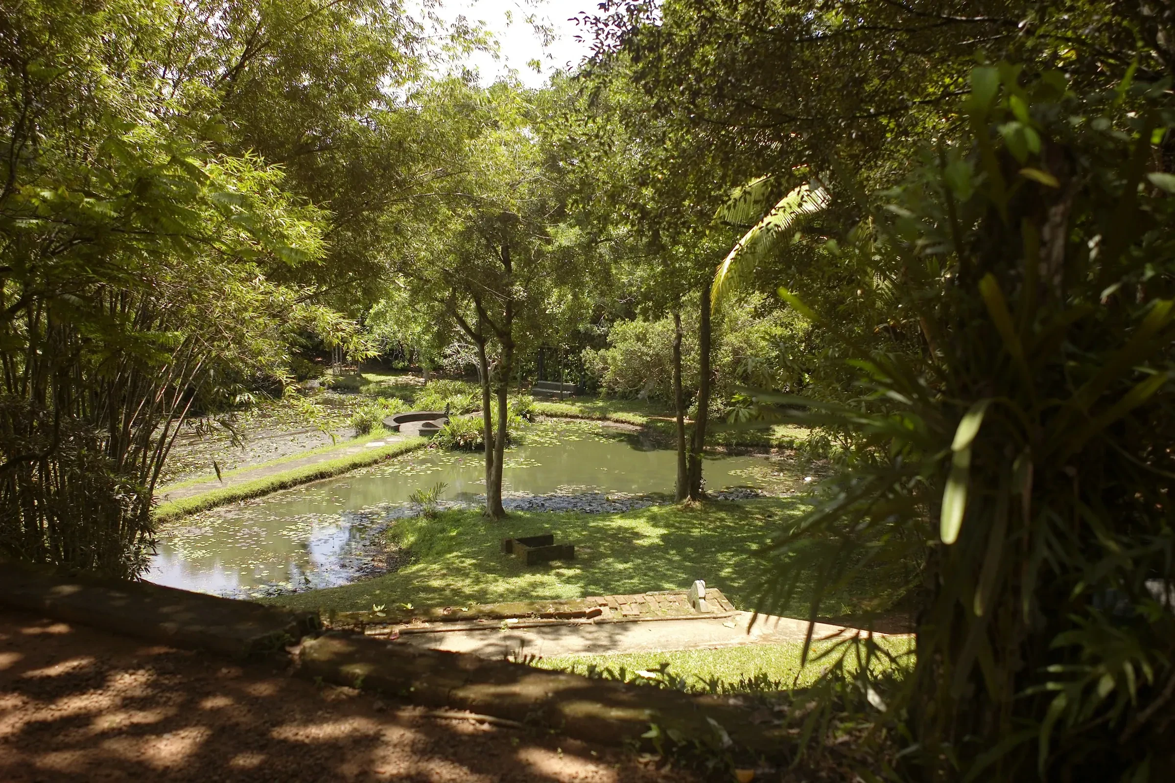 A pond and shaded lawns in the gardens of Geoffrey Bawa's Lunuganga estate near Bentota