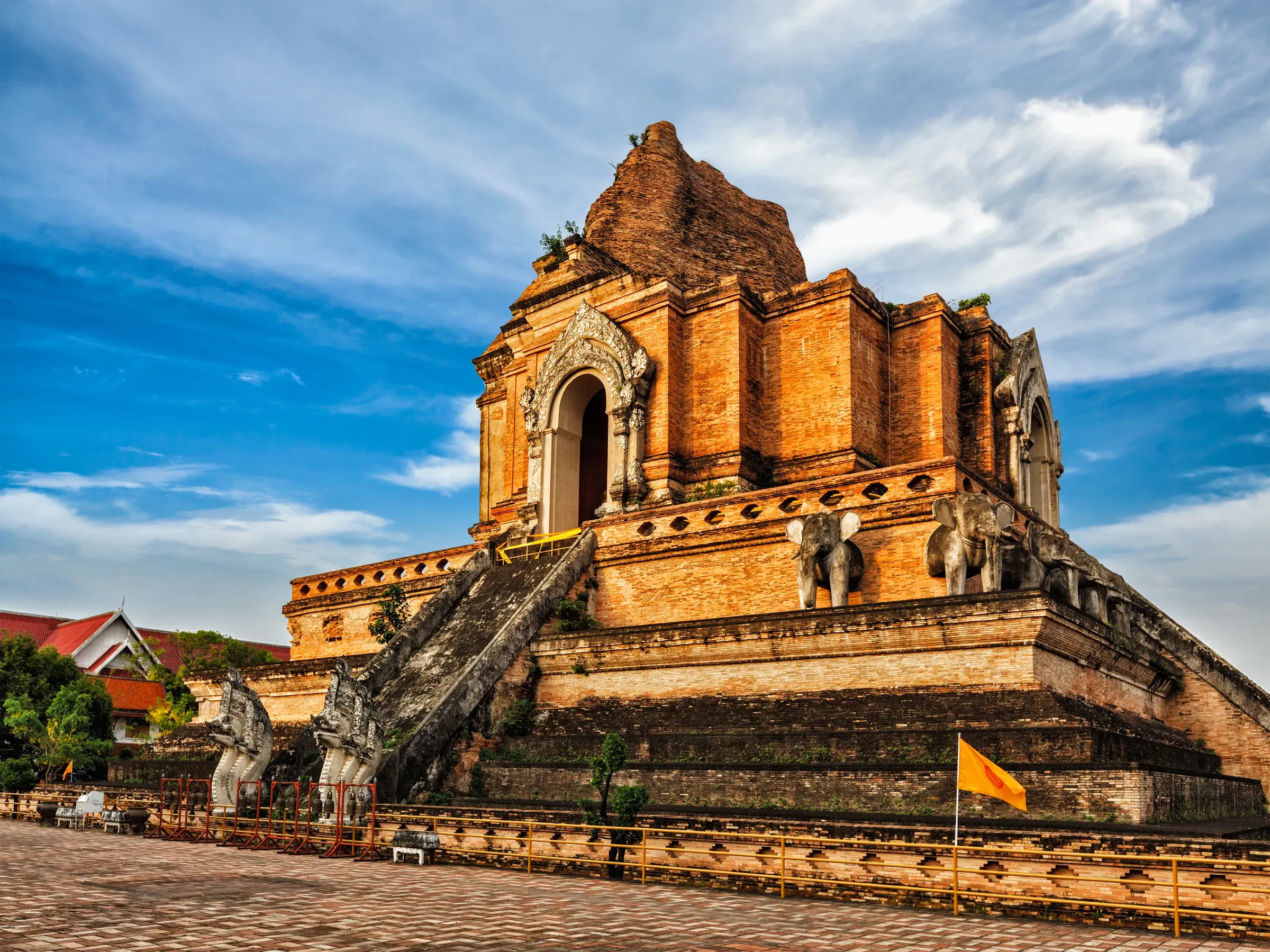 Wat Chedi Luang's ruined brick chedi in Chiang Mai's Old City, with a few visitors walking through