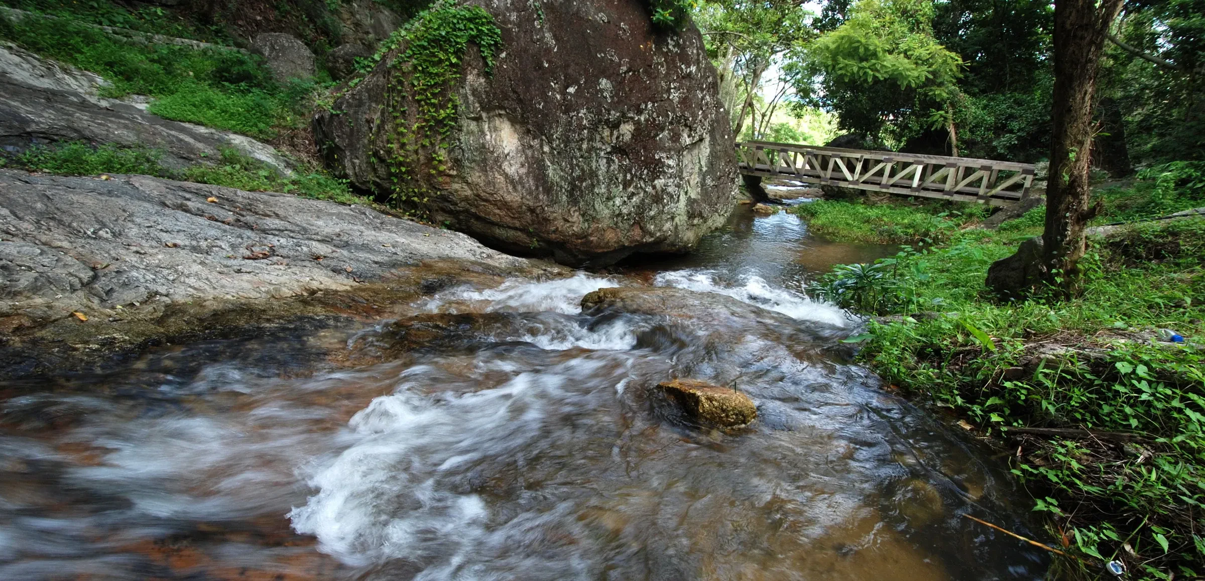 The lower reaches of Huai Kaew Waterfall near Chiang Mai running full through green forest in the rainy season.