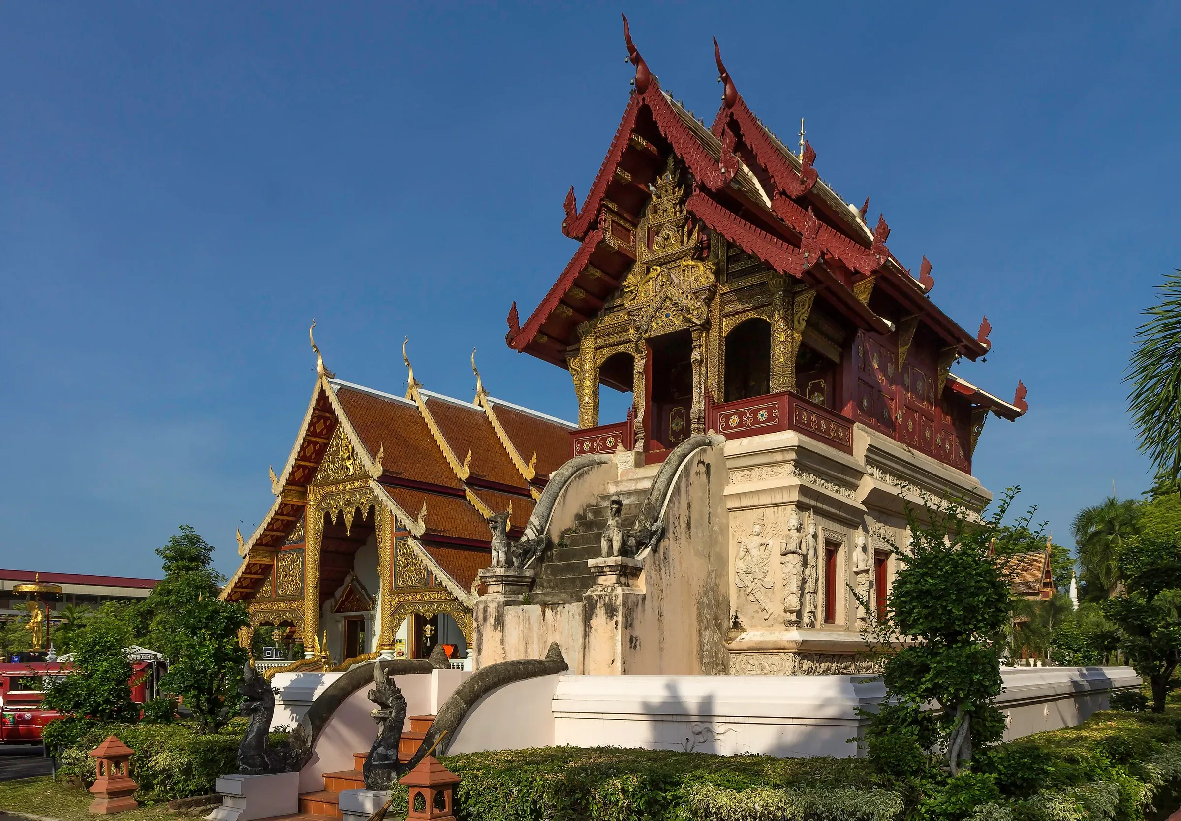 The carved wooden viharn of Wat Phra Singh in Chiang Mai's Old City, with a tiered roof under a deep blue sky.