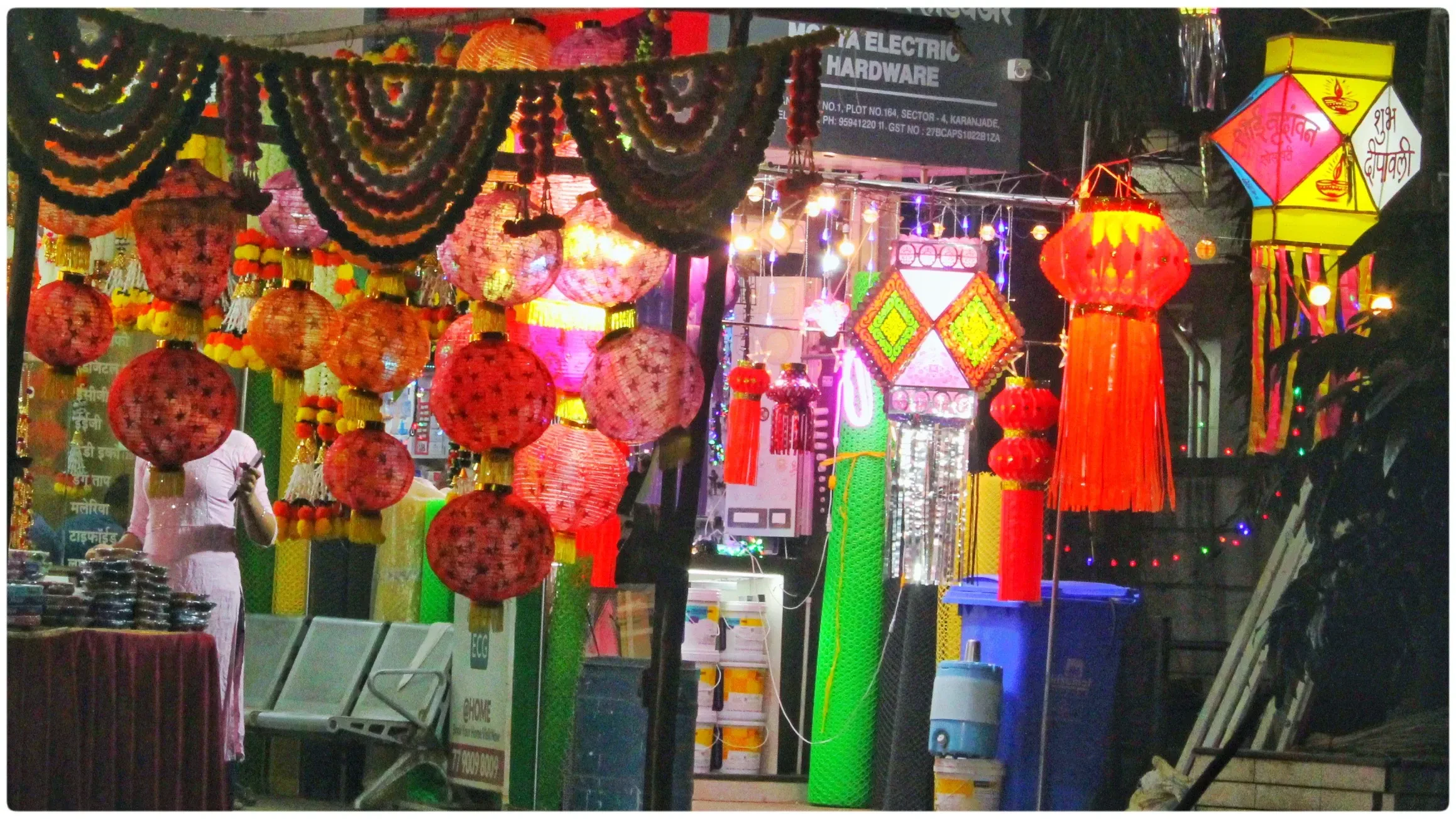 Paper lanterns in red and gold hanging at a street market stall during Diwali