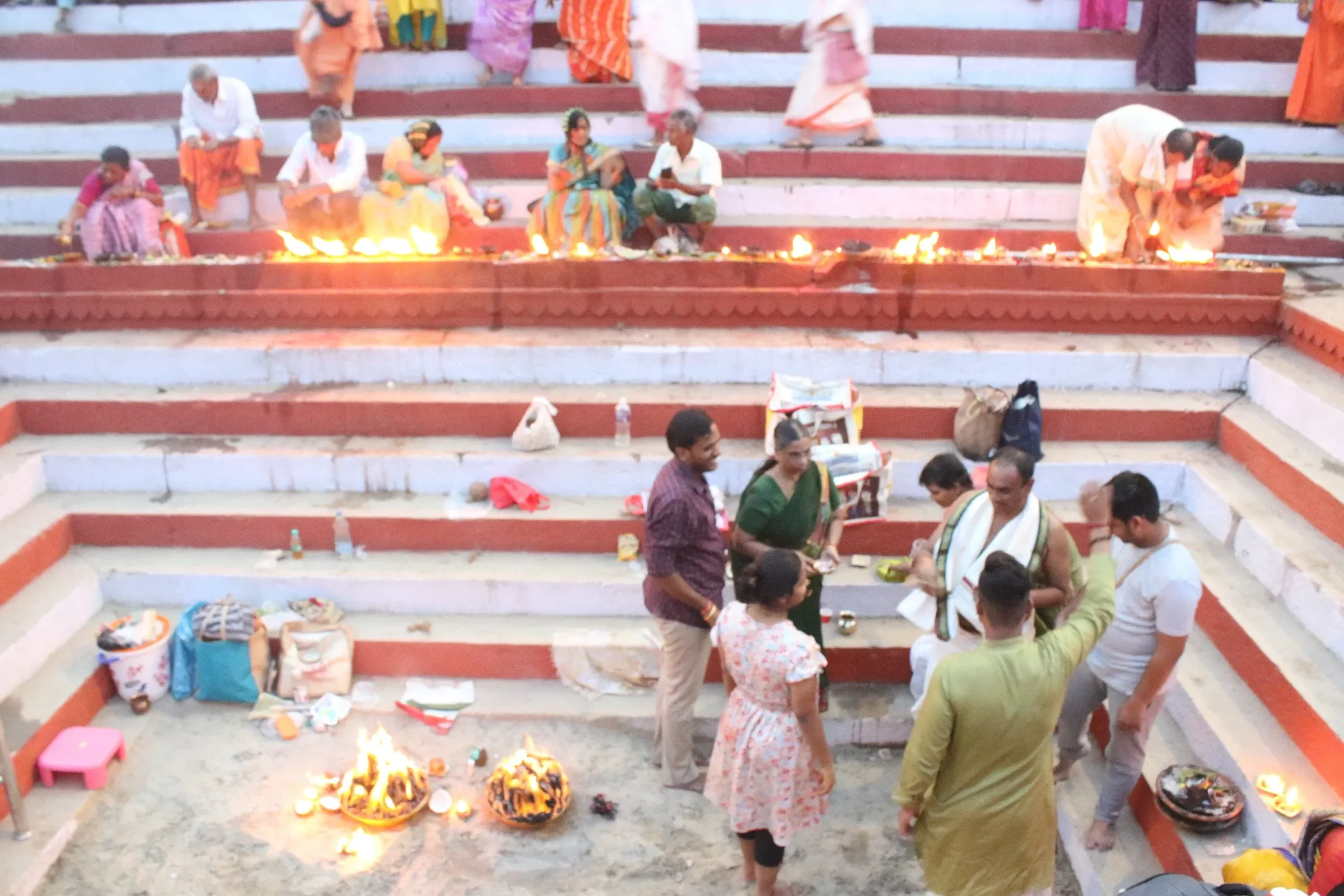 Devotees tending lit lamps on the ghat steps in Varanasi during Dev Deepawali