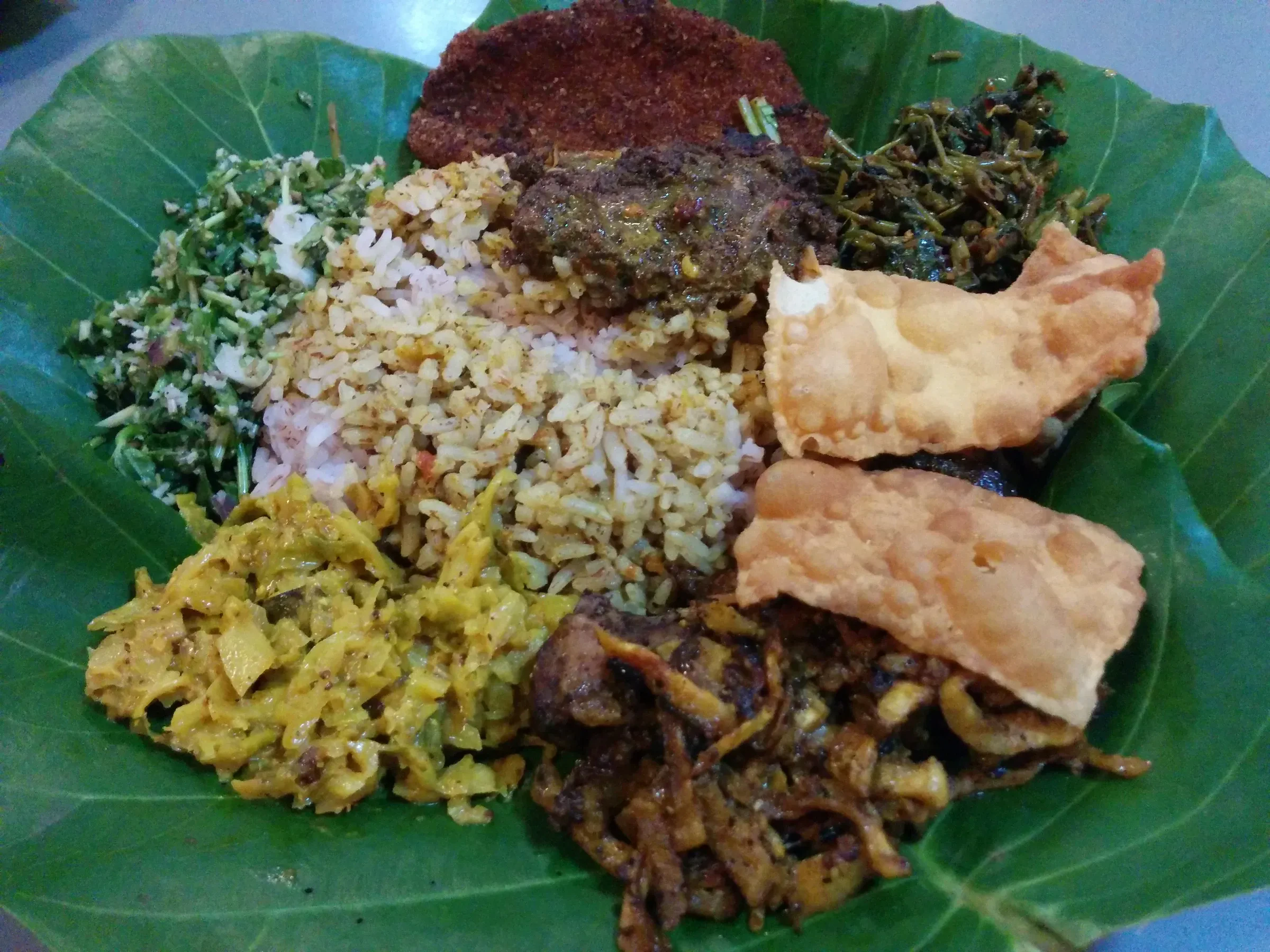 Sri Lankan rice and curry on a banana leaf with papadums and sambols