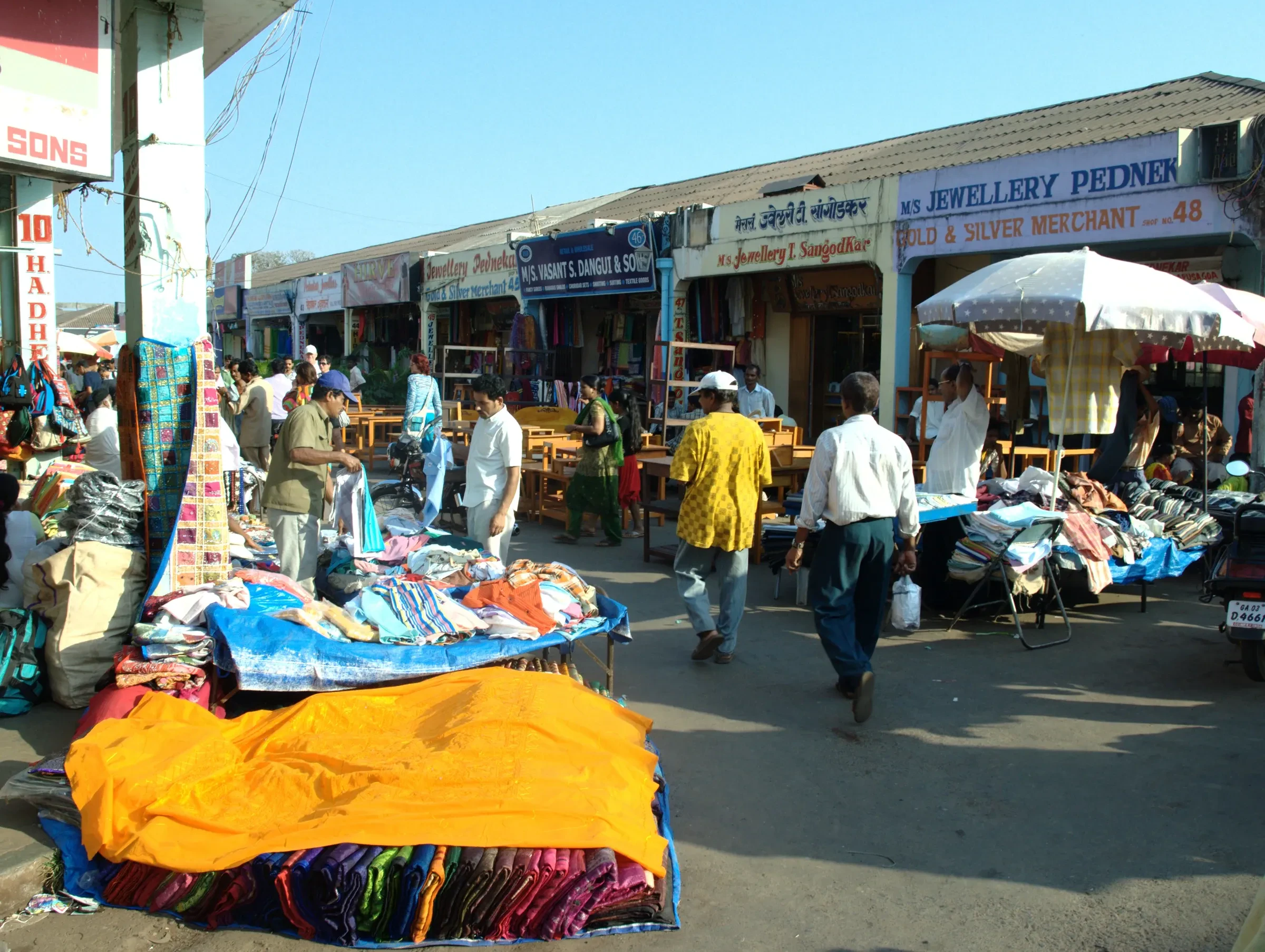Stalls and shoppers along a lane at Mapusa's Friday market in North Goa