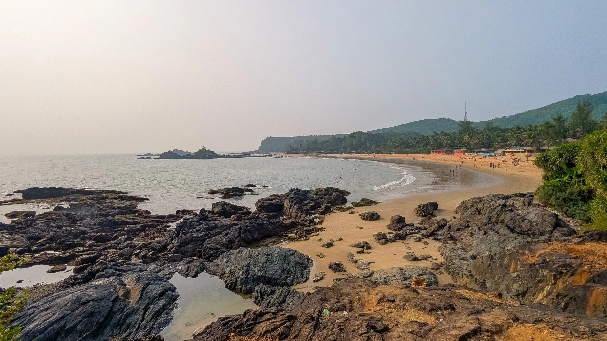 Rocks and the long curve of Om Beach at Gokarna
