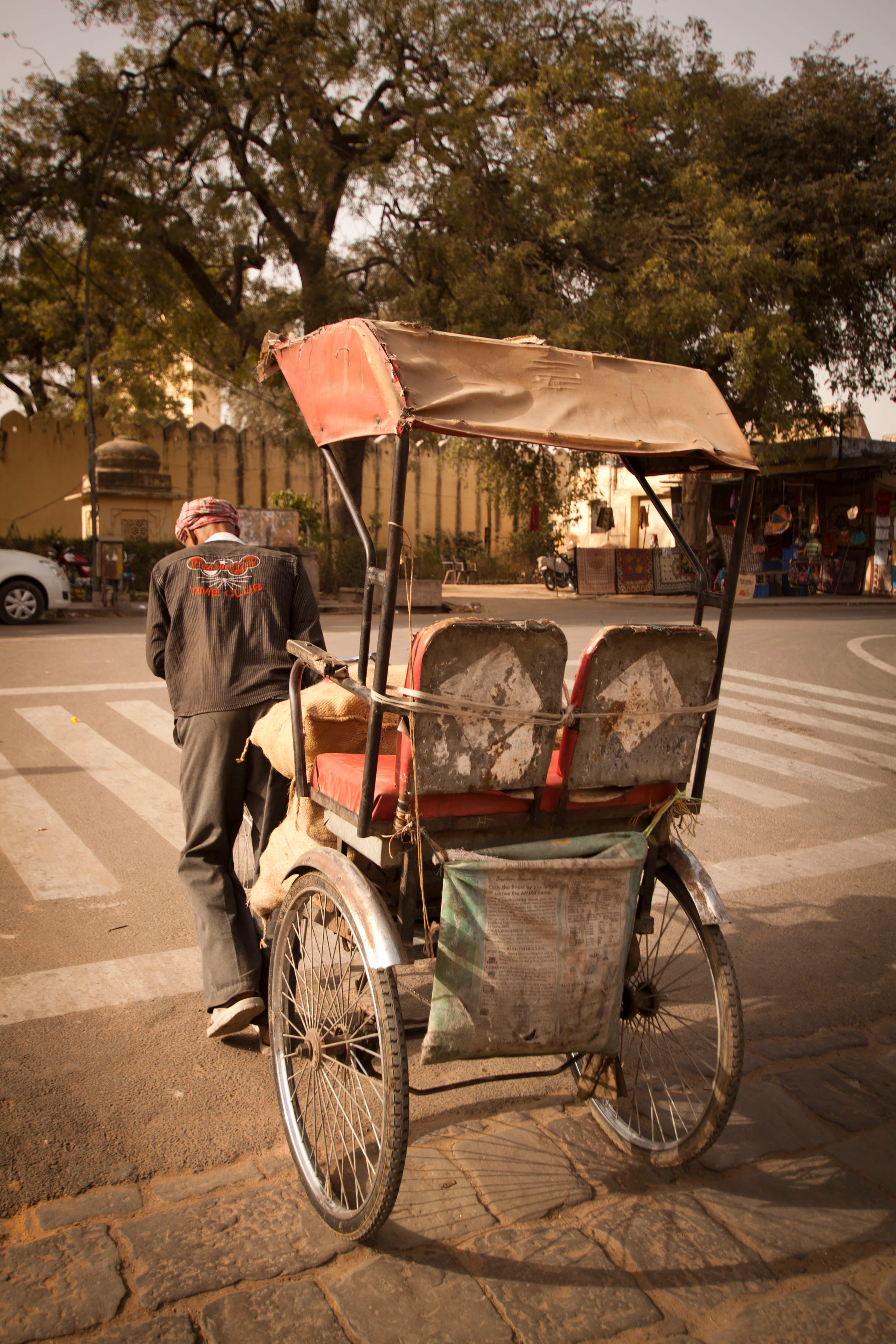 A cycle rickshaw carrying a passenger through an Old Delhi street