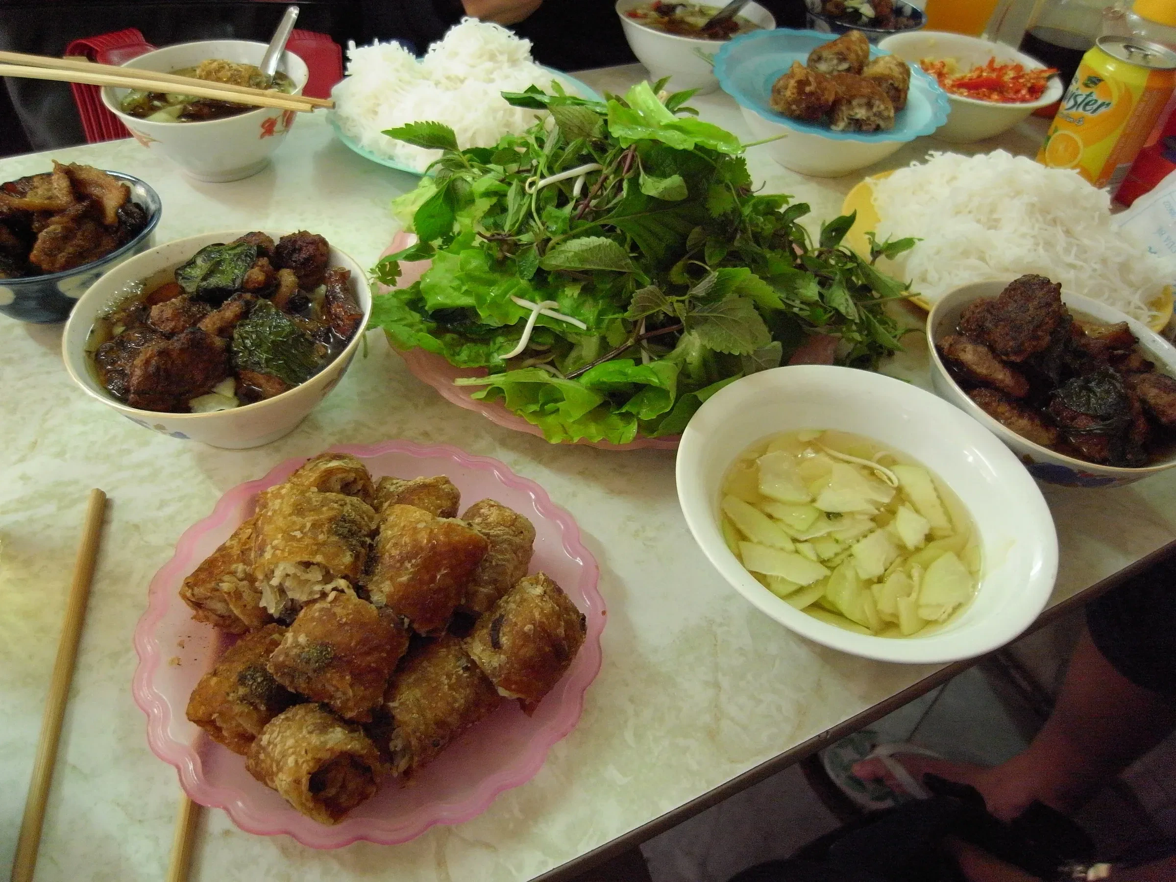 A bun cha spread in Hanoi with grilled pork, nem rolls and herbs