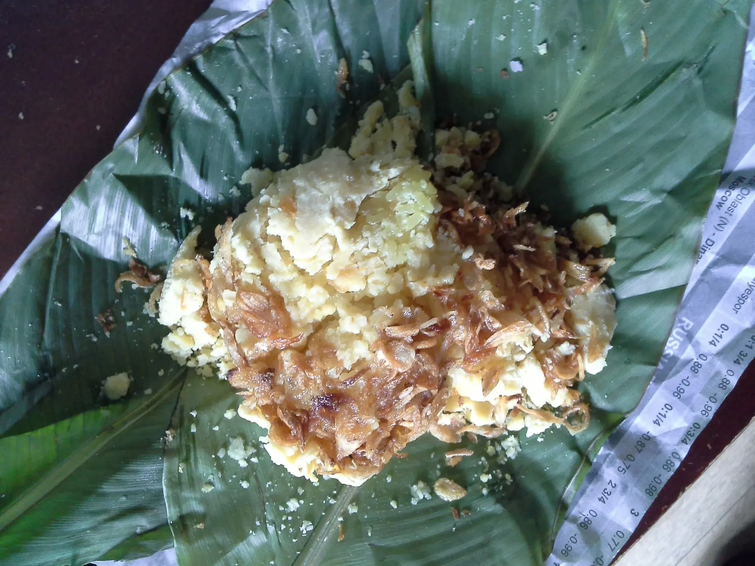 Xoi xeo, sticky rice with mung bean and fried shallots, on a banana leaf