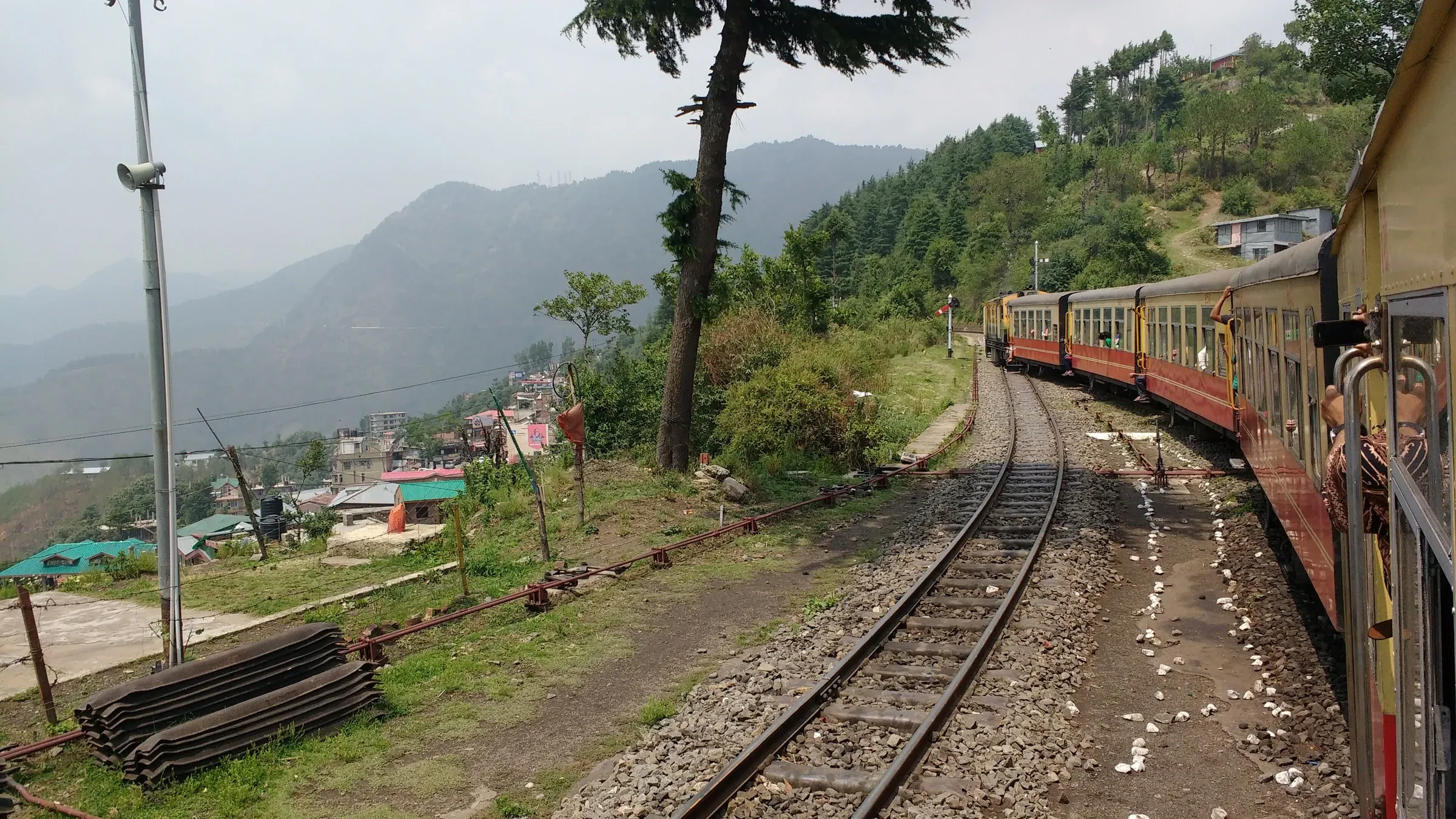 The Kalka-Shimla toy train curving along the track above a hill town