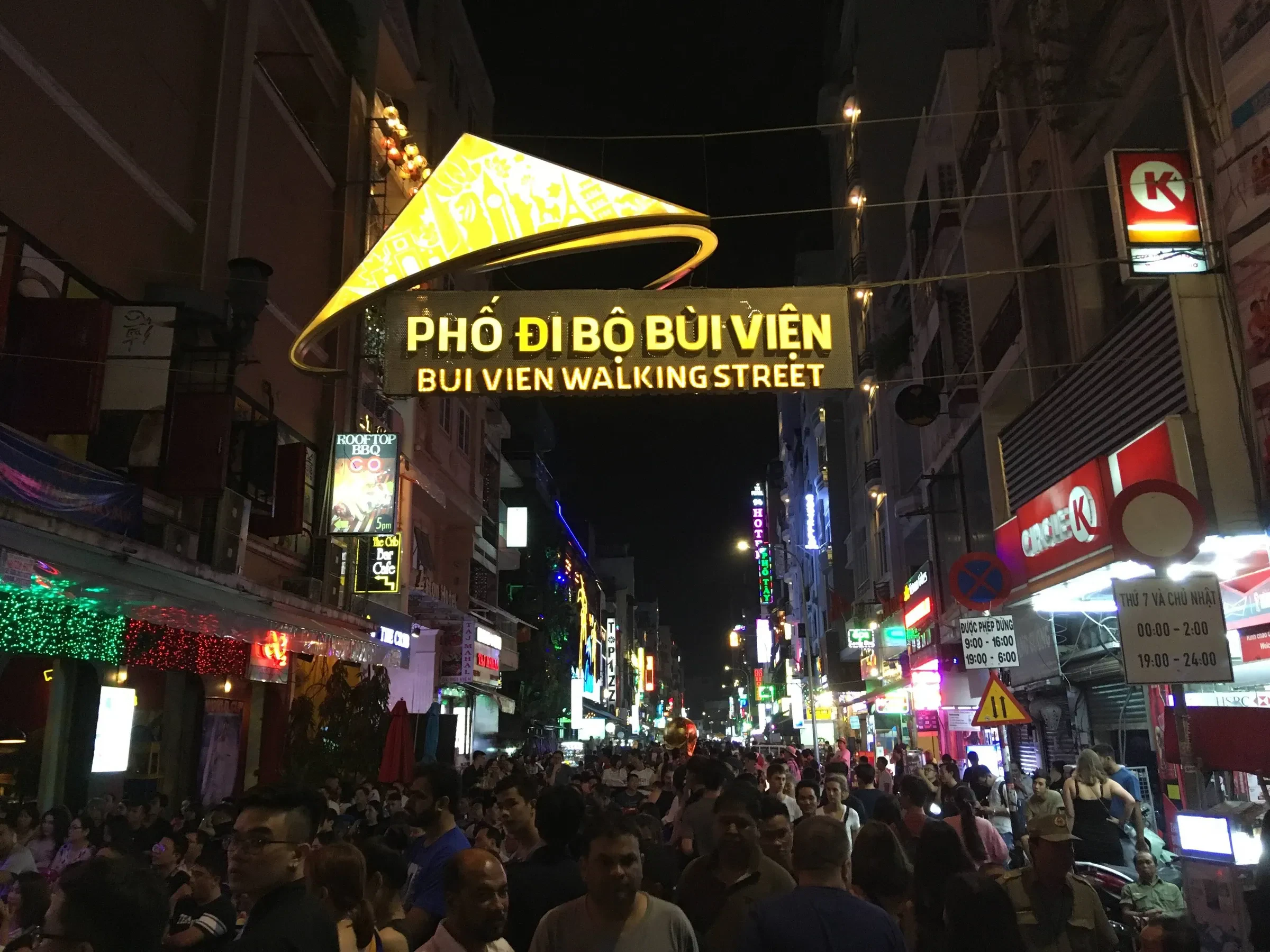 The Bui Vien walking street sign over a crowded, neon-lit street in Ho Chi Minh City at night