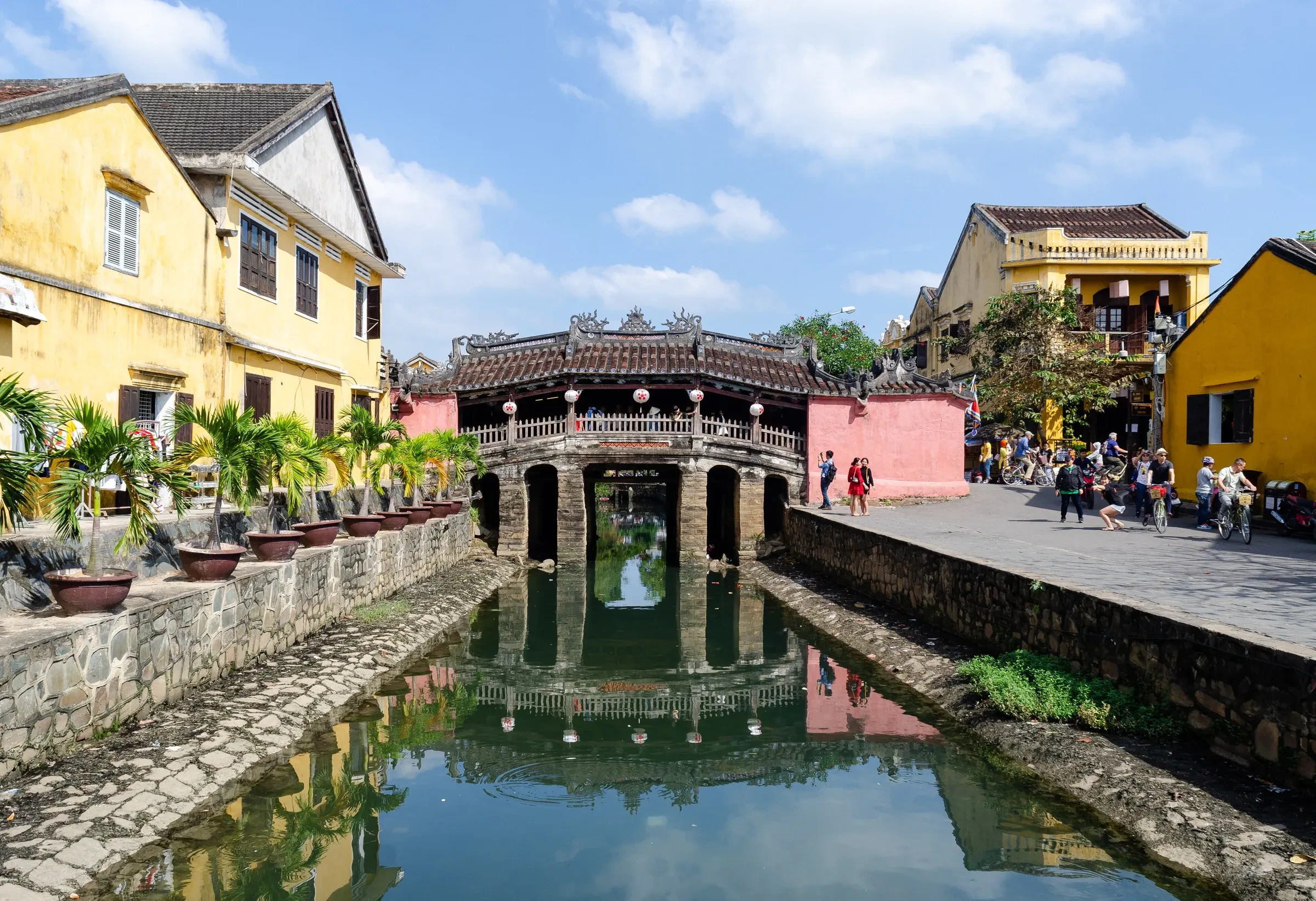 The Japanese Covered Bridge and yellow-walled old town houses in Hoi An by day