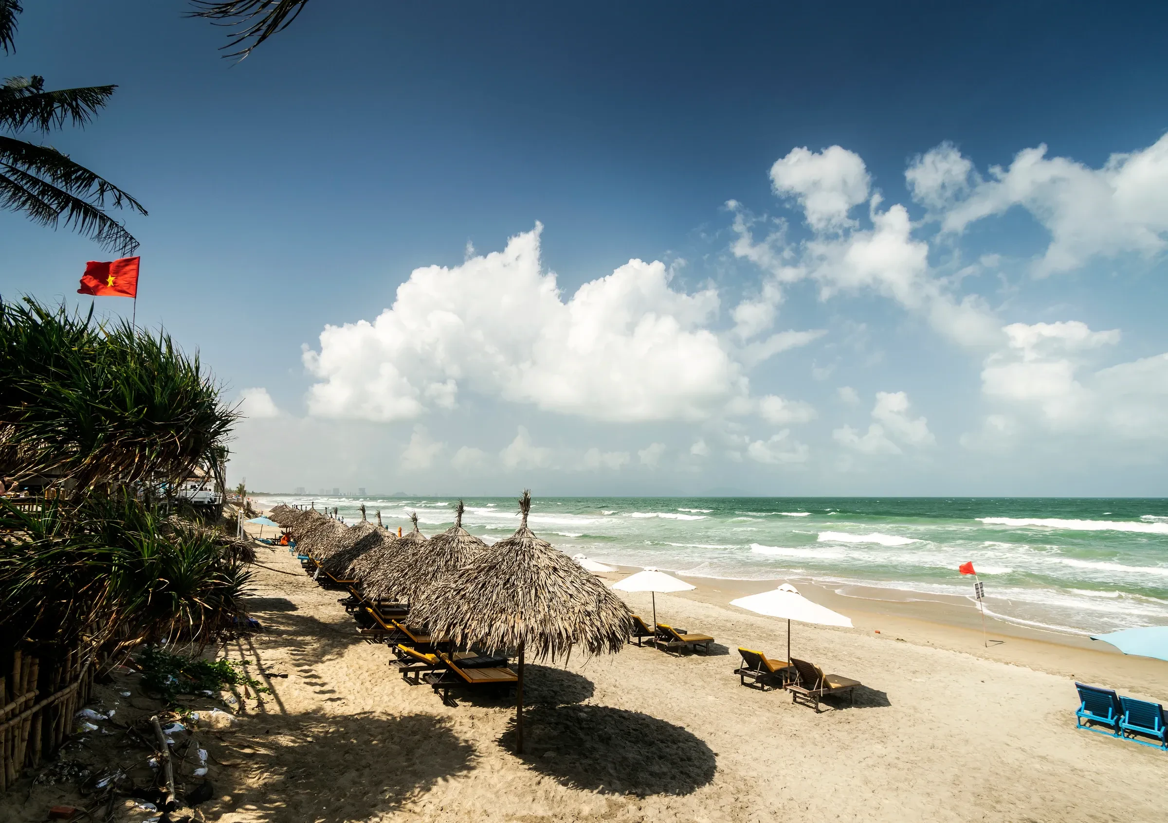 Thatched sunshades and sun loungers along An Bang beach near Hoi An