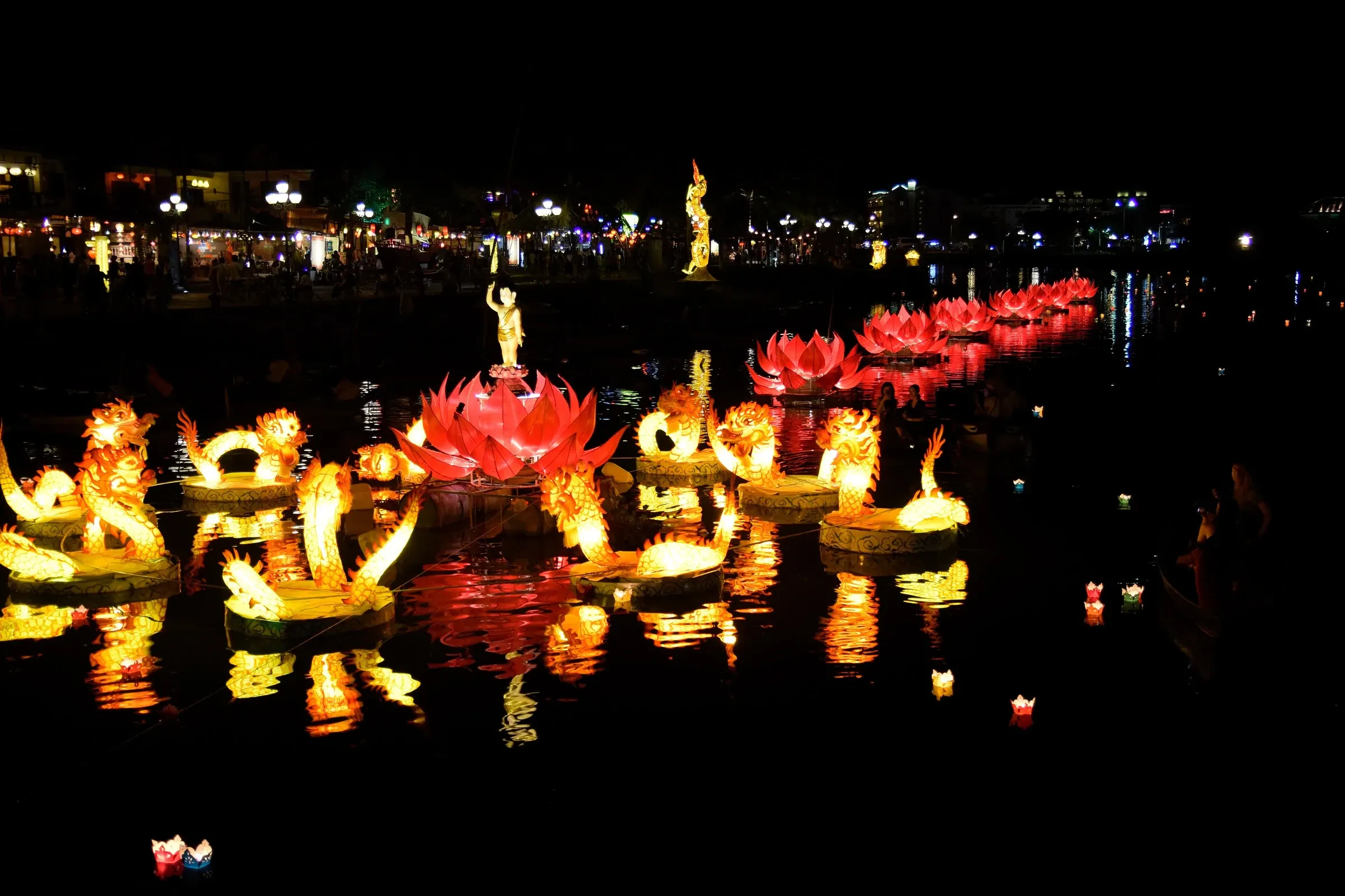 Large lotus and dragon shaped lanterns floating on the river in Hoi An at night