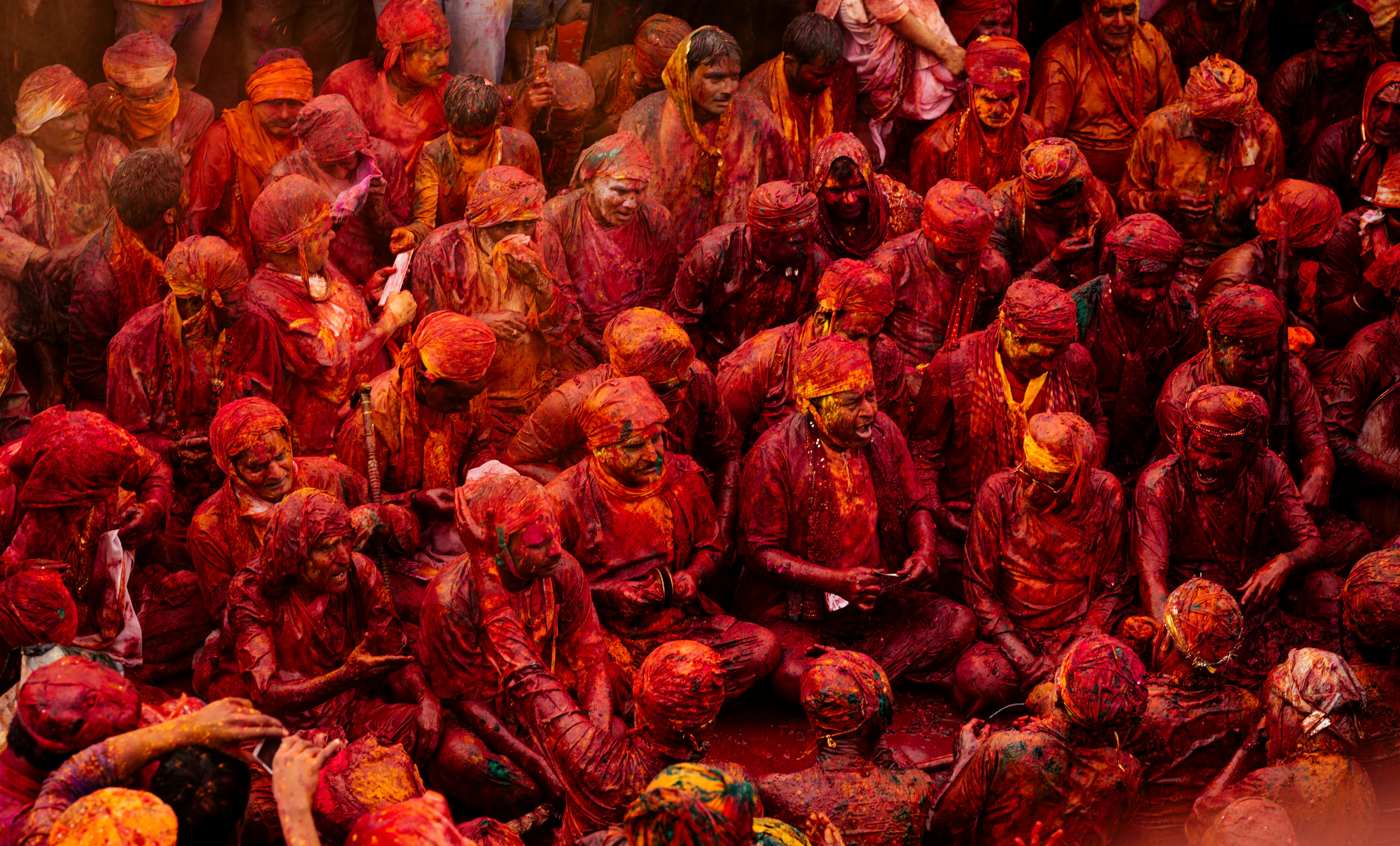 People throwing clouds of coloured powder into the air during Holi celebrations