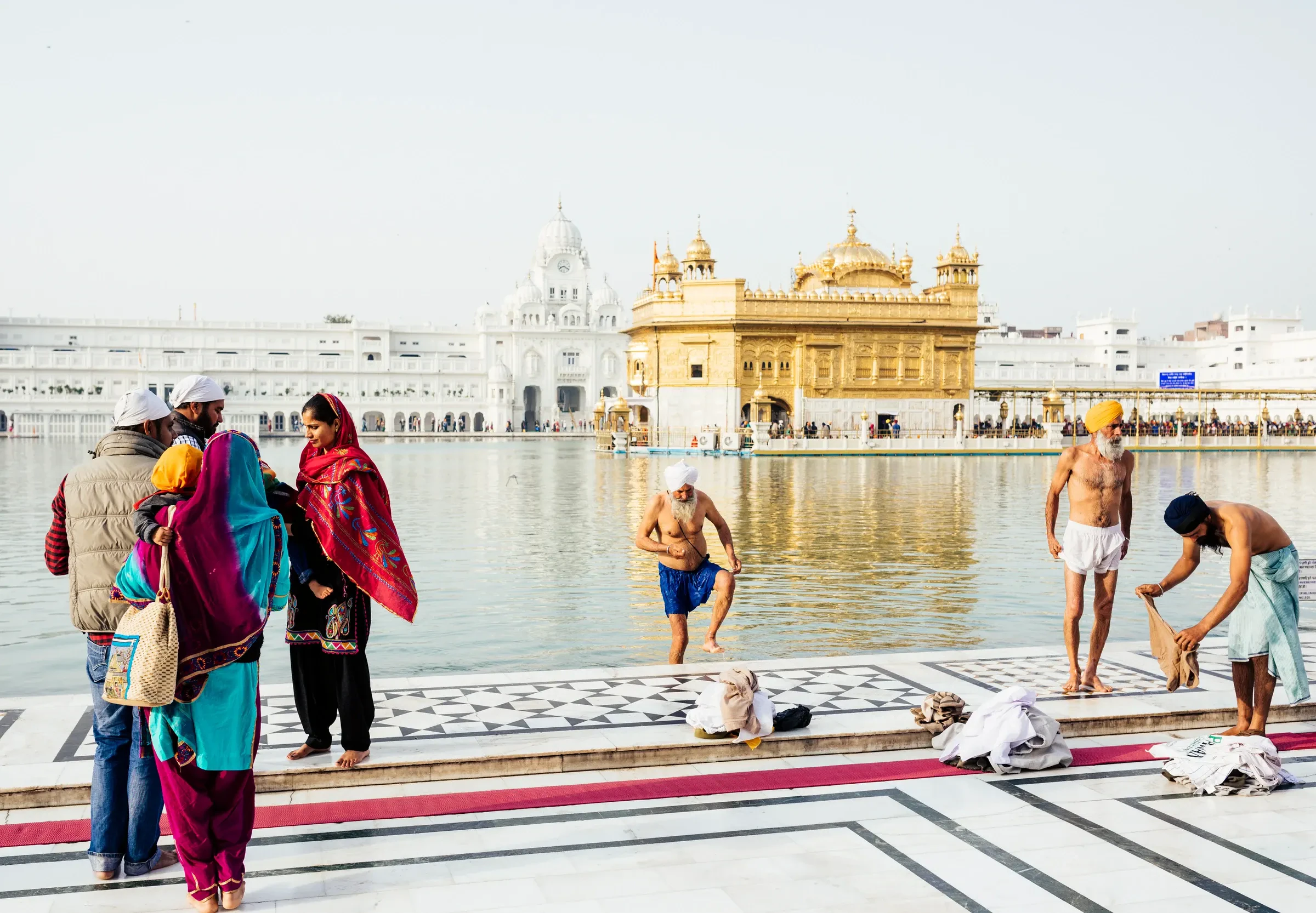 Pilgrims on the marble walkway beside the sacred pool at the Golden Temple, Amritsar