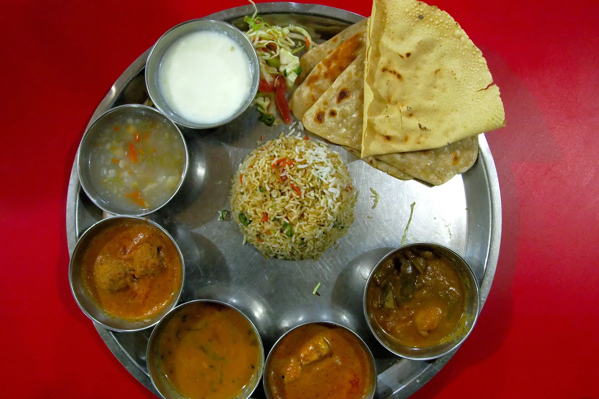 A thali, a metal plate of curries, rice, flatbread and curd served as one meal