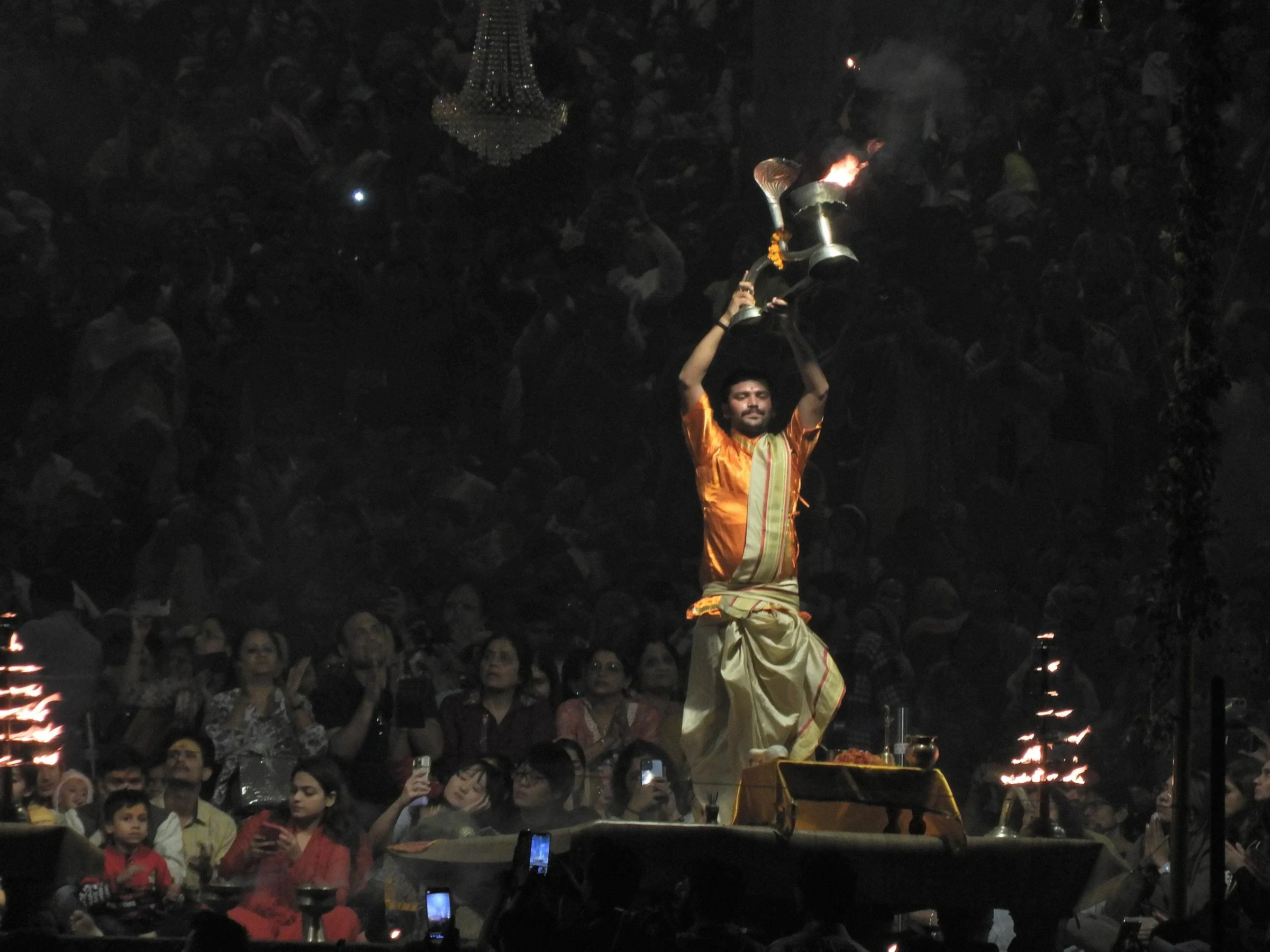 A priest raising a fire lamp during the Ganga Aarti before a packed crowd in Varanasi on Dev Deepawali