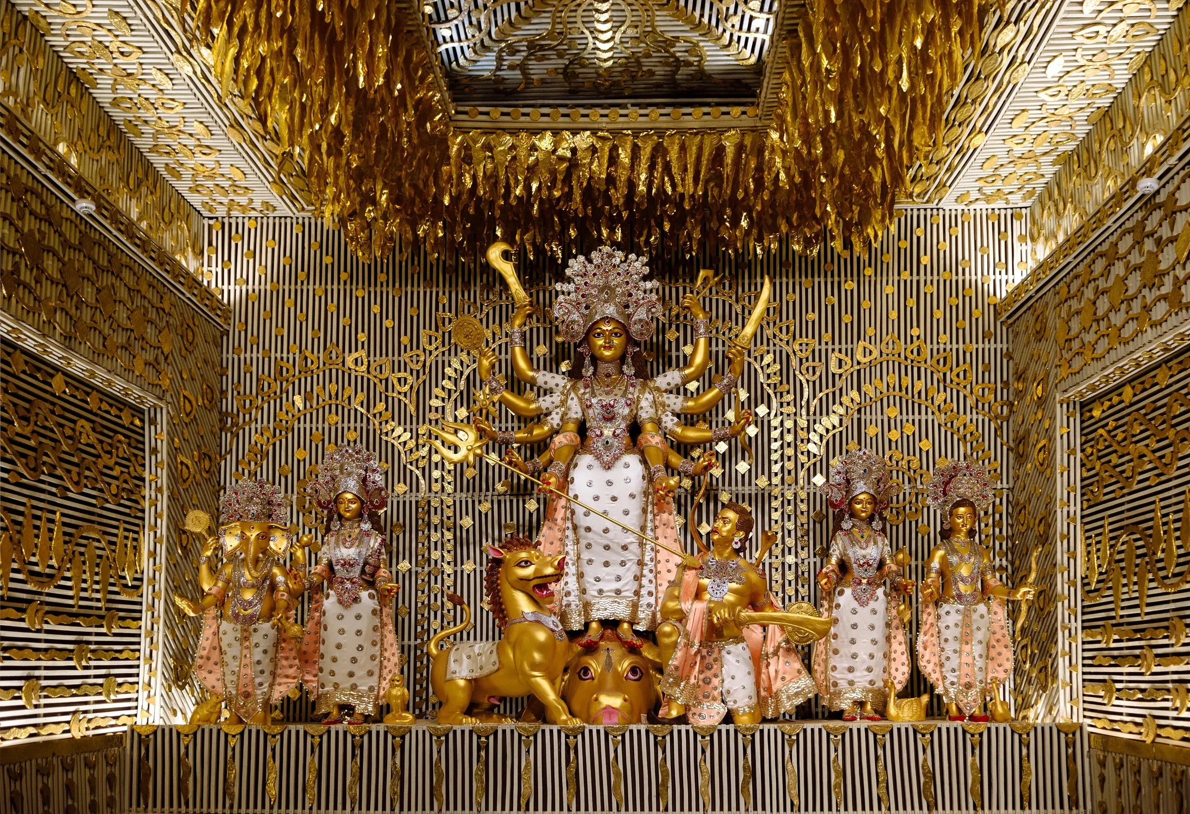The goddess Durga with her children in a gilded pandal at Chalta Bagan in North Kolkata