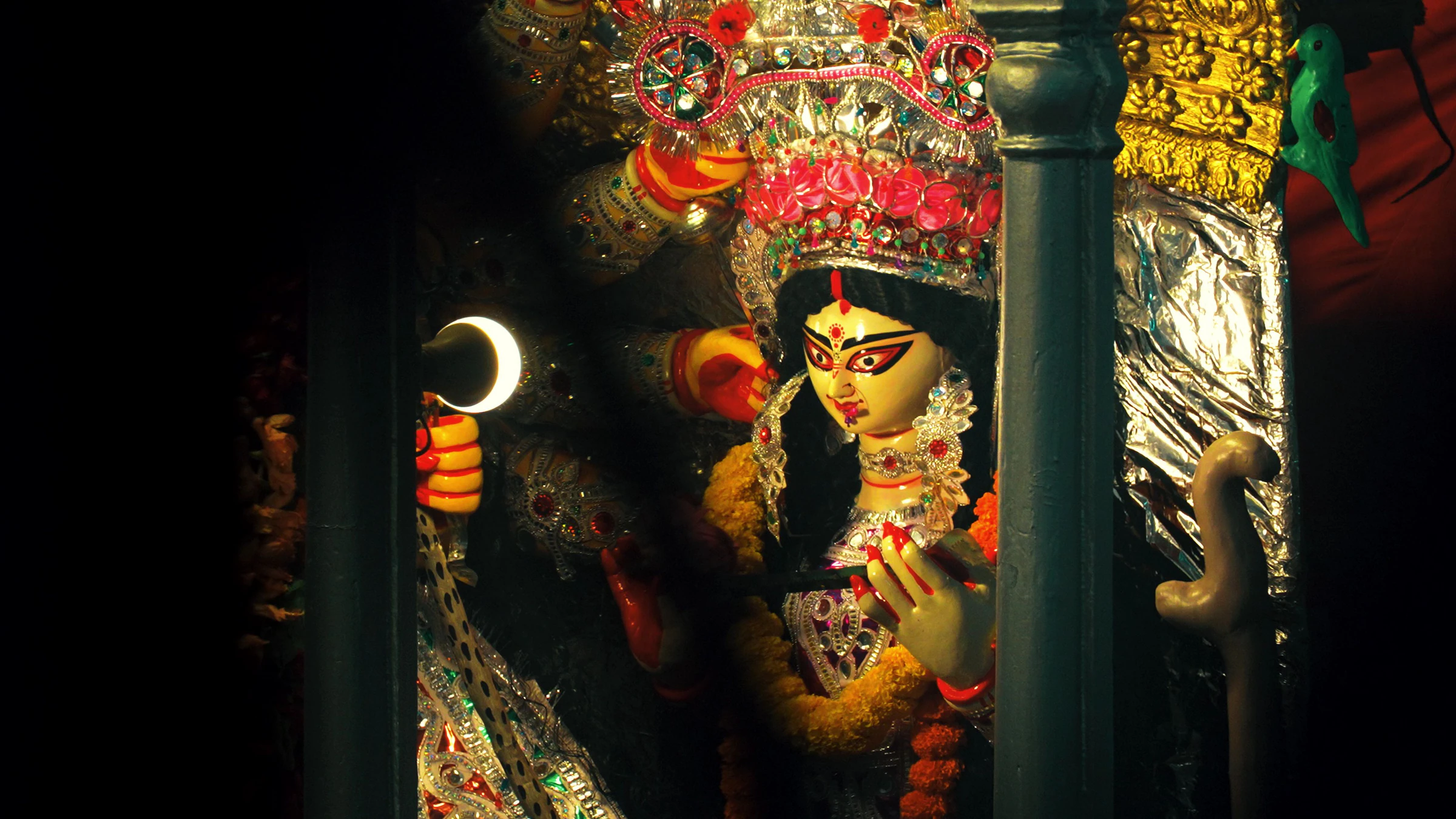A brightly lit, elaborately decorated Durga Puja pandal in Kolkata at night