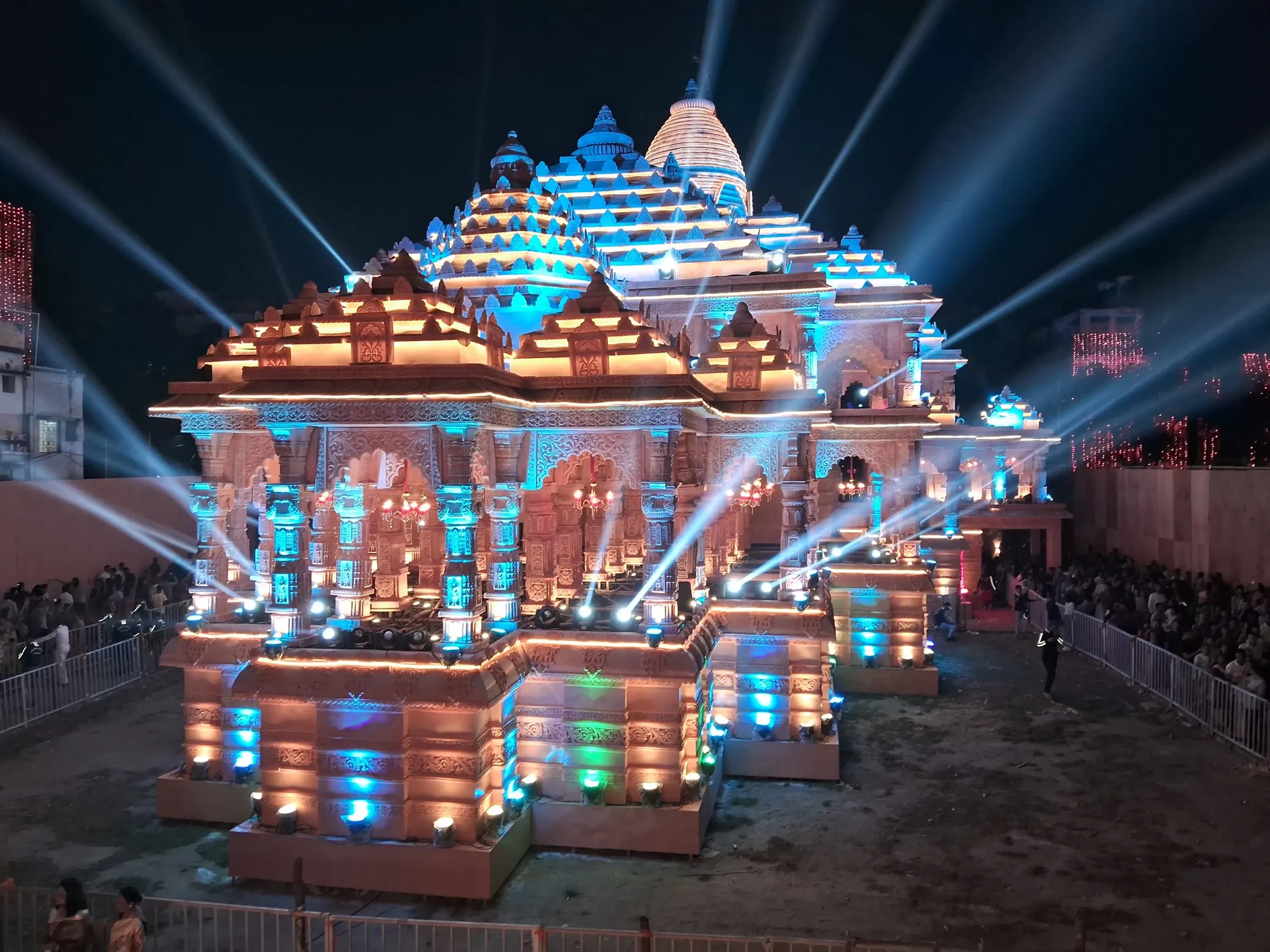 A Durga Puja pandal in Kolkata built as a temple replica and lit with coloured beams at night