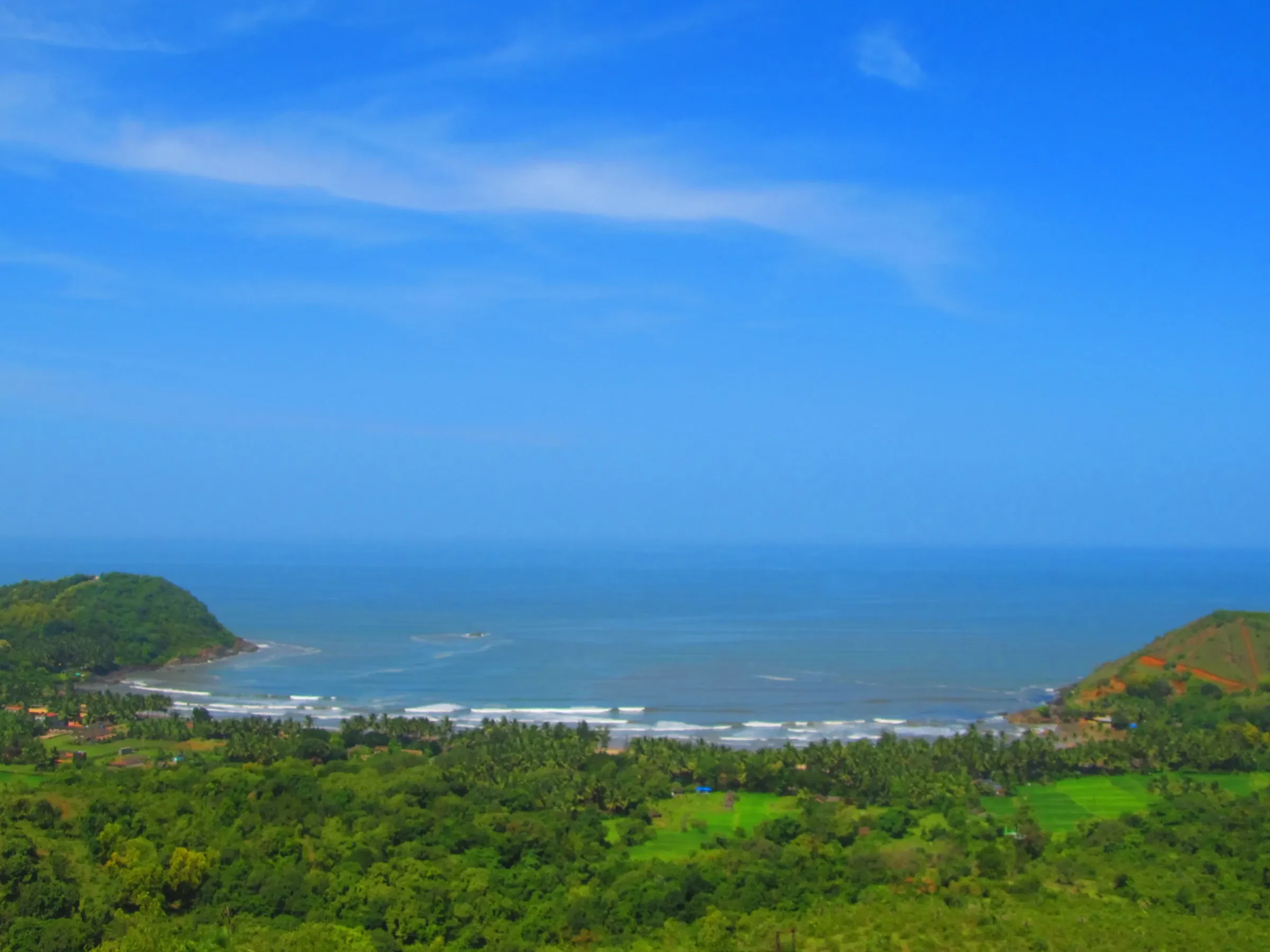 Kudle Beach seen from the hillside above, with green headlands on either side
