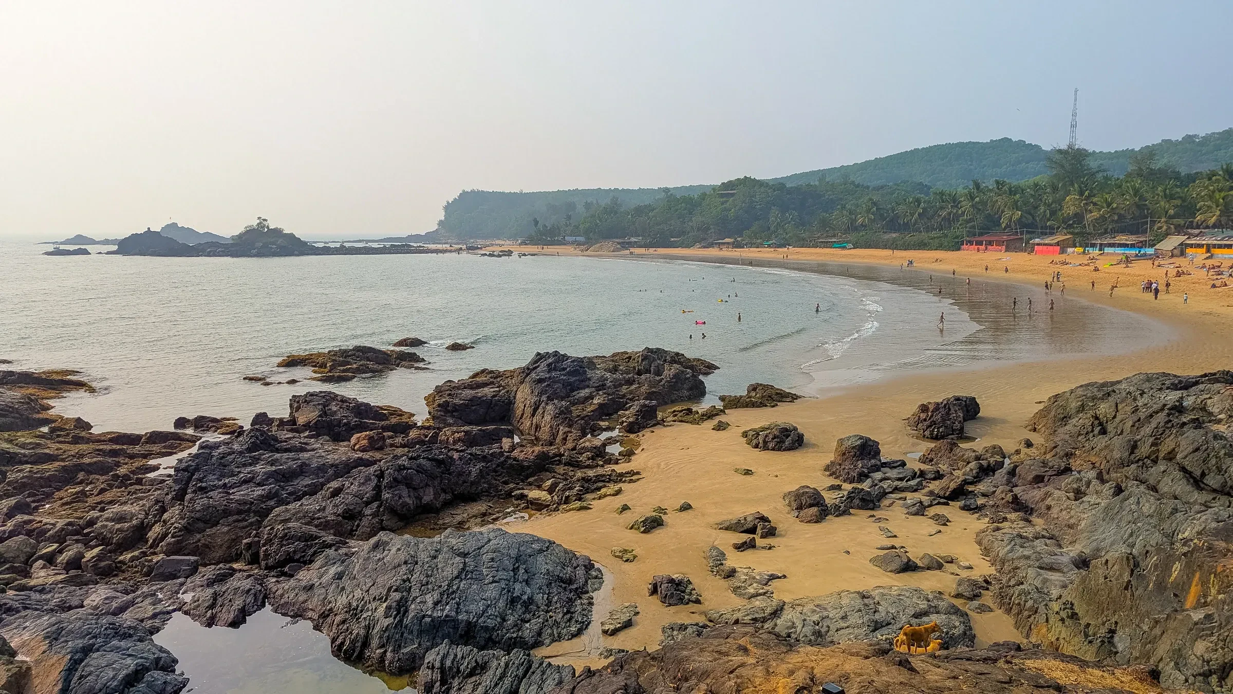 Om Beach's curve of sand seen over dark rocks, Gokarna