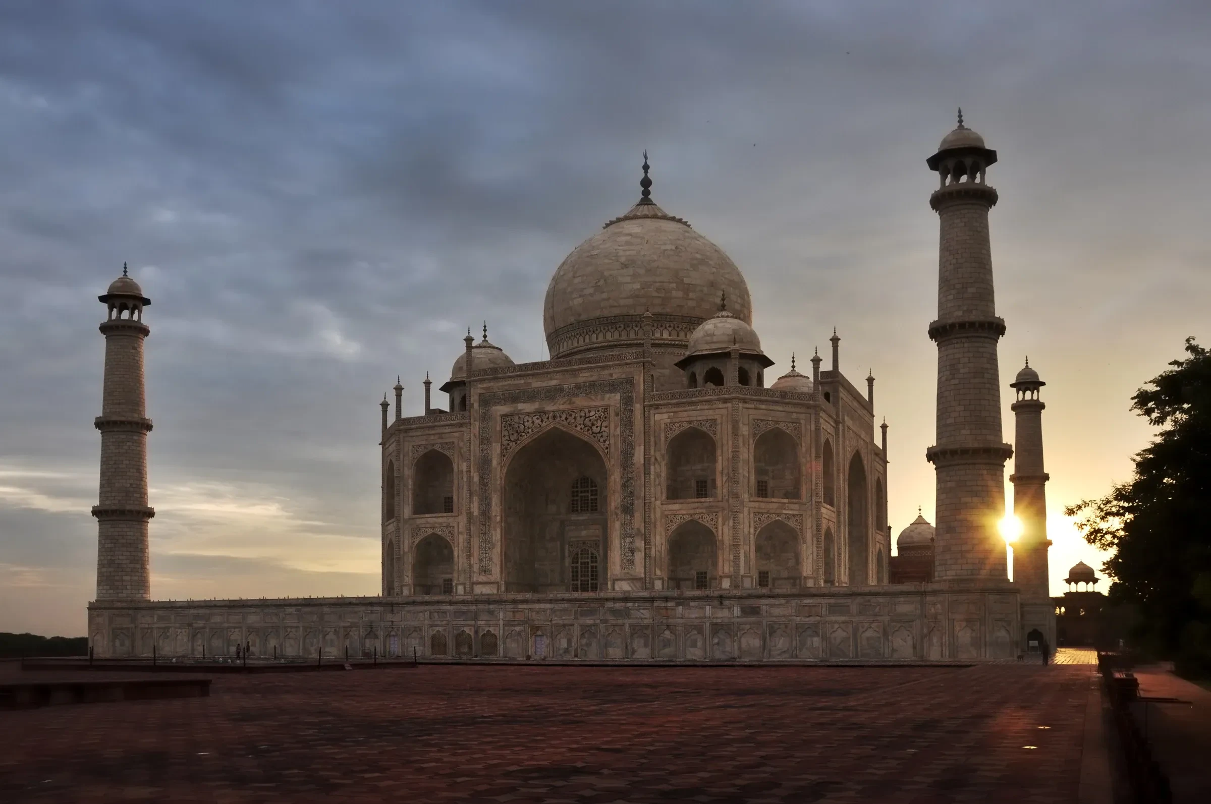 The Taj Mahal at sunrise, seen across the paving of its forecourt