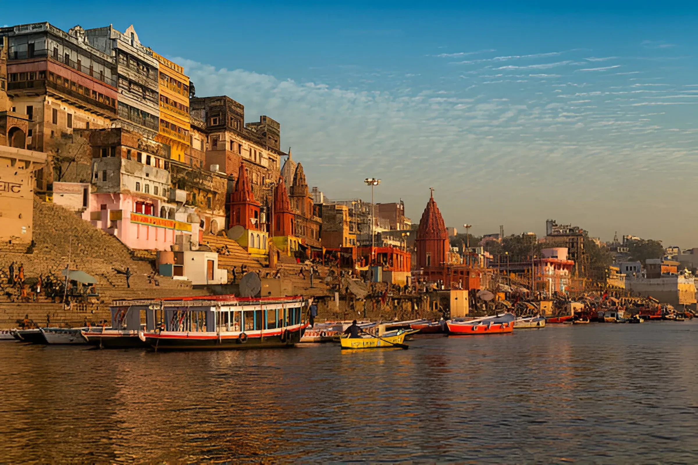 Boats and old riverside buildings along the ghats at Varanasi in golden light