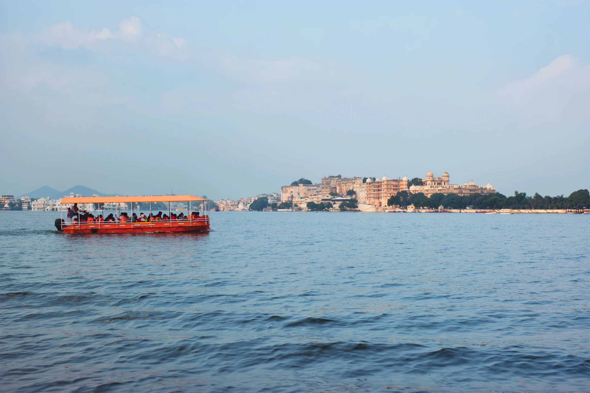 A tourist boat on Lake Pichola, with Udaipur's City Palace on the far shore