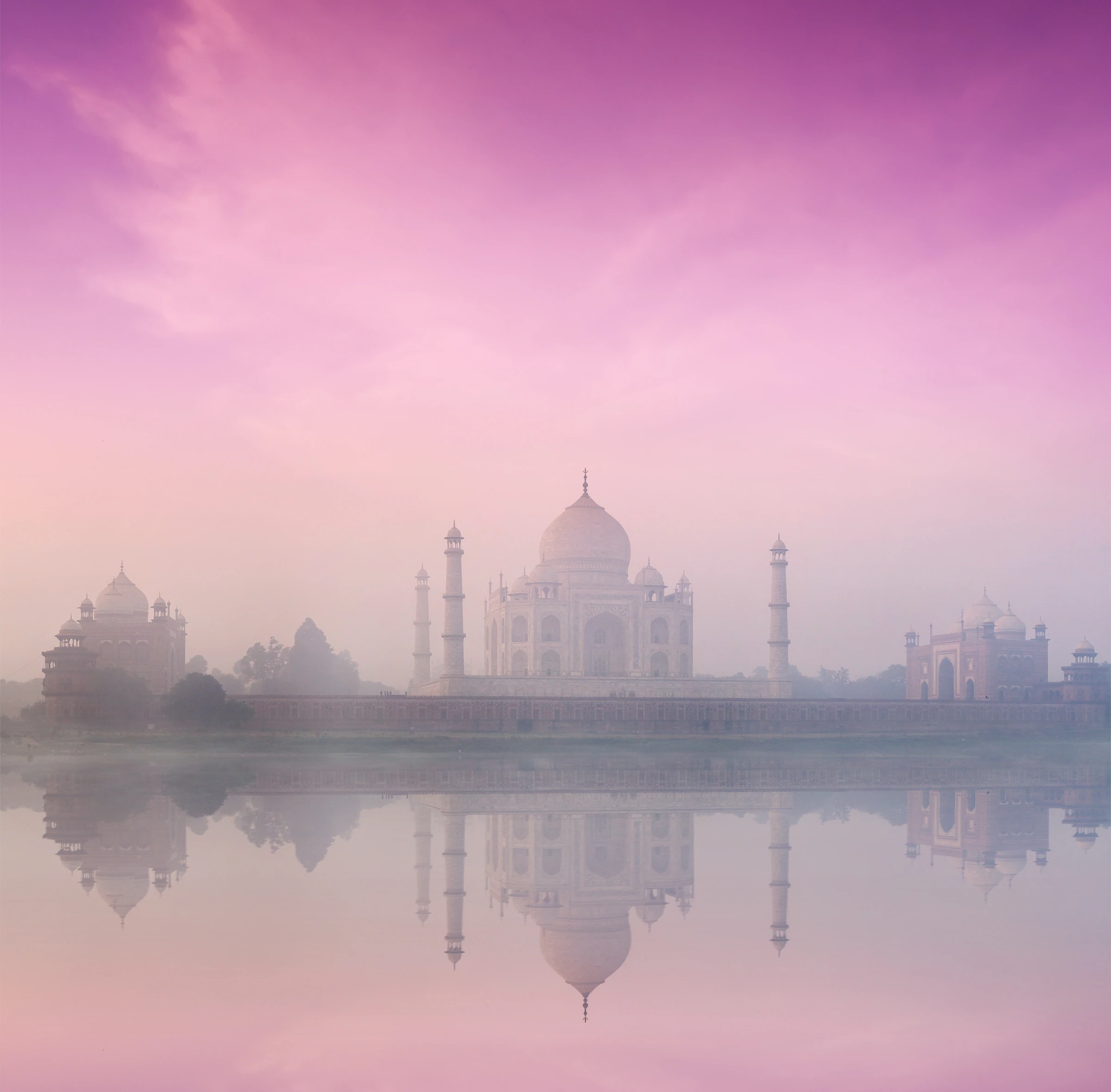 The Taj Mahal at sunrise, seen across its long reflecting pool