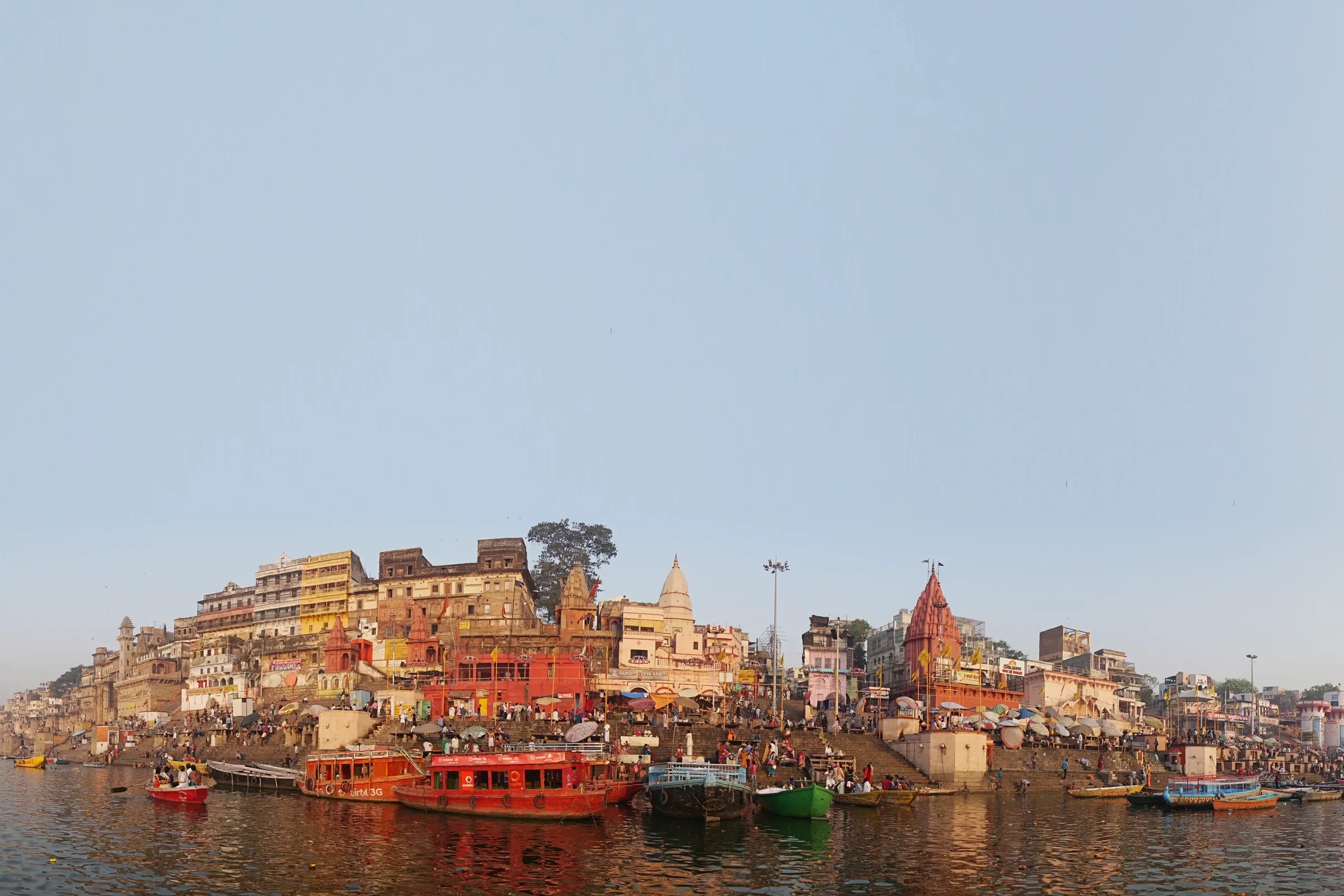 The ghats of Varanasi seen from the Ganges, with boats along the water