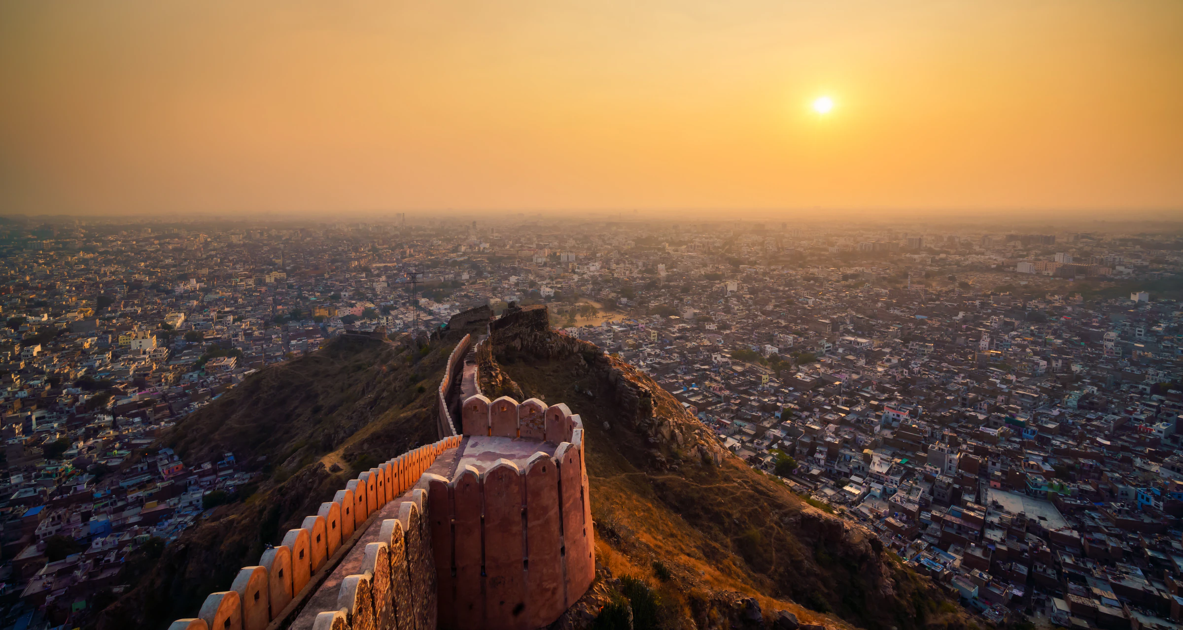 The Pink City seen from above at sunset, with Nahargarh Fort's ramparts in the foreground