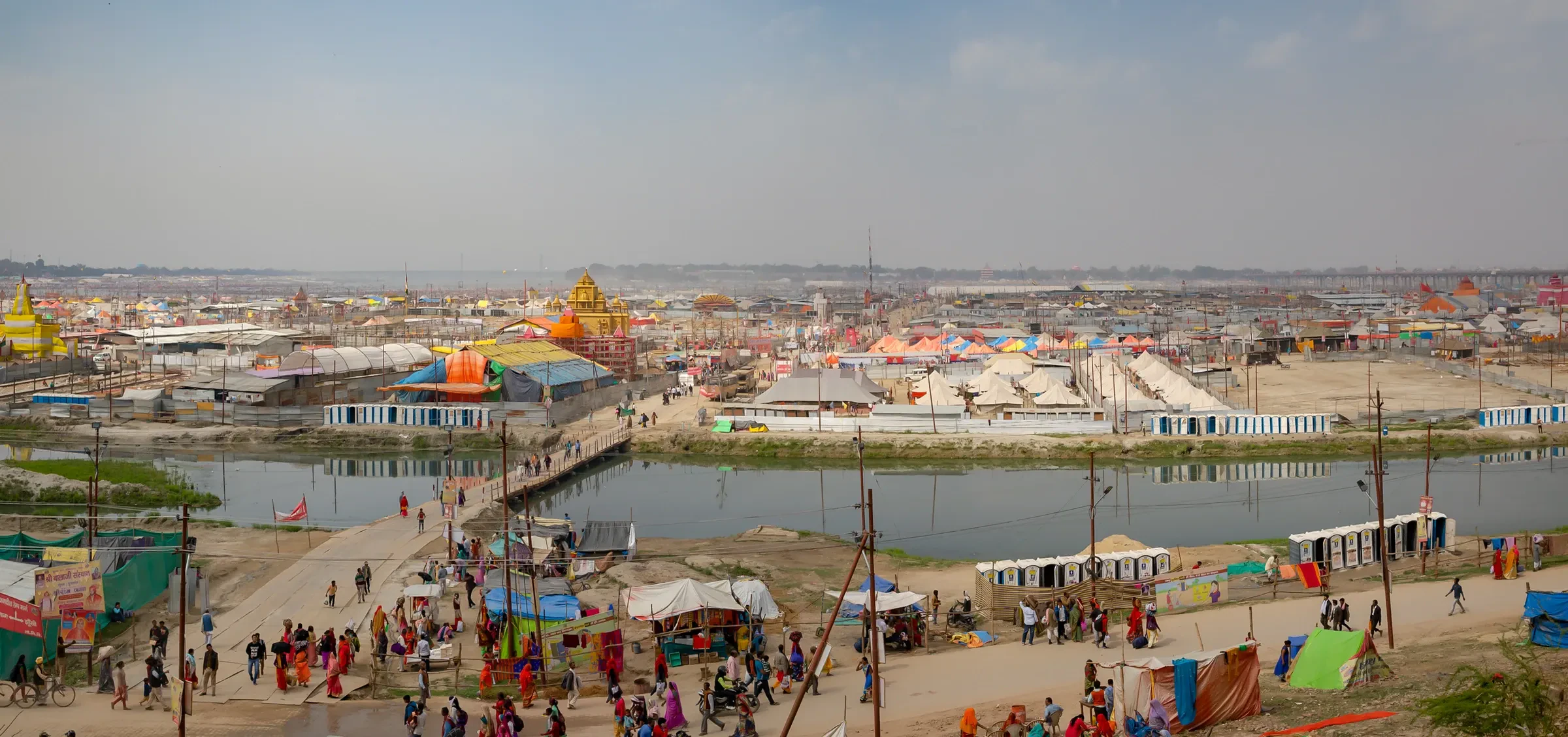 A panorama of the Kumbh Mela tent city beside the river at Prayagraj