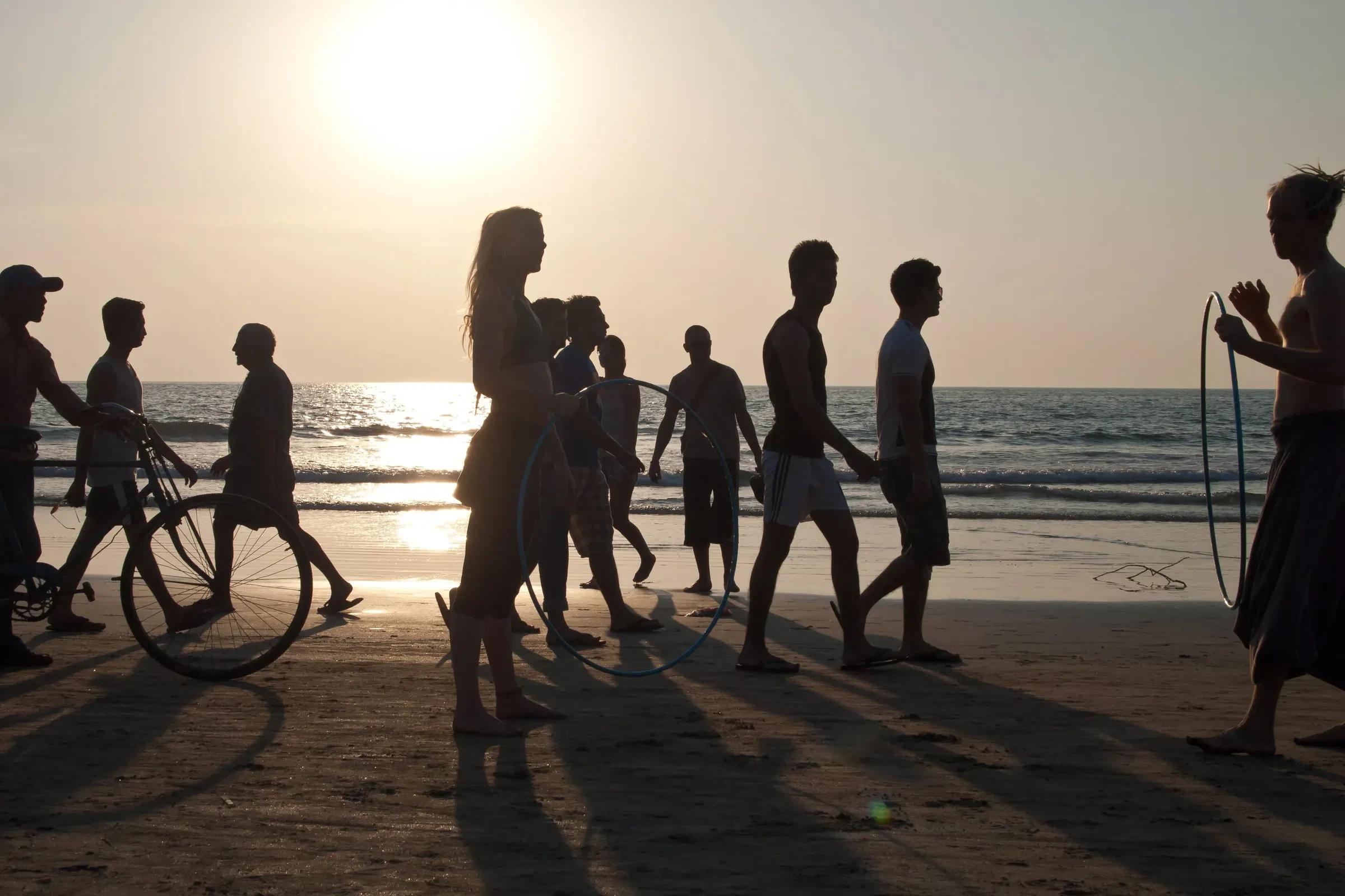 People silhouetted against the sunset on Arambol beach in North Goa