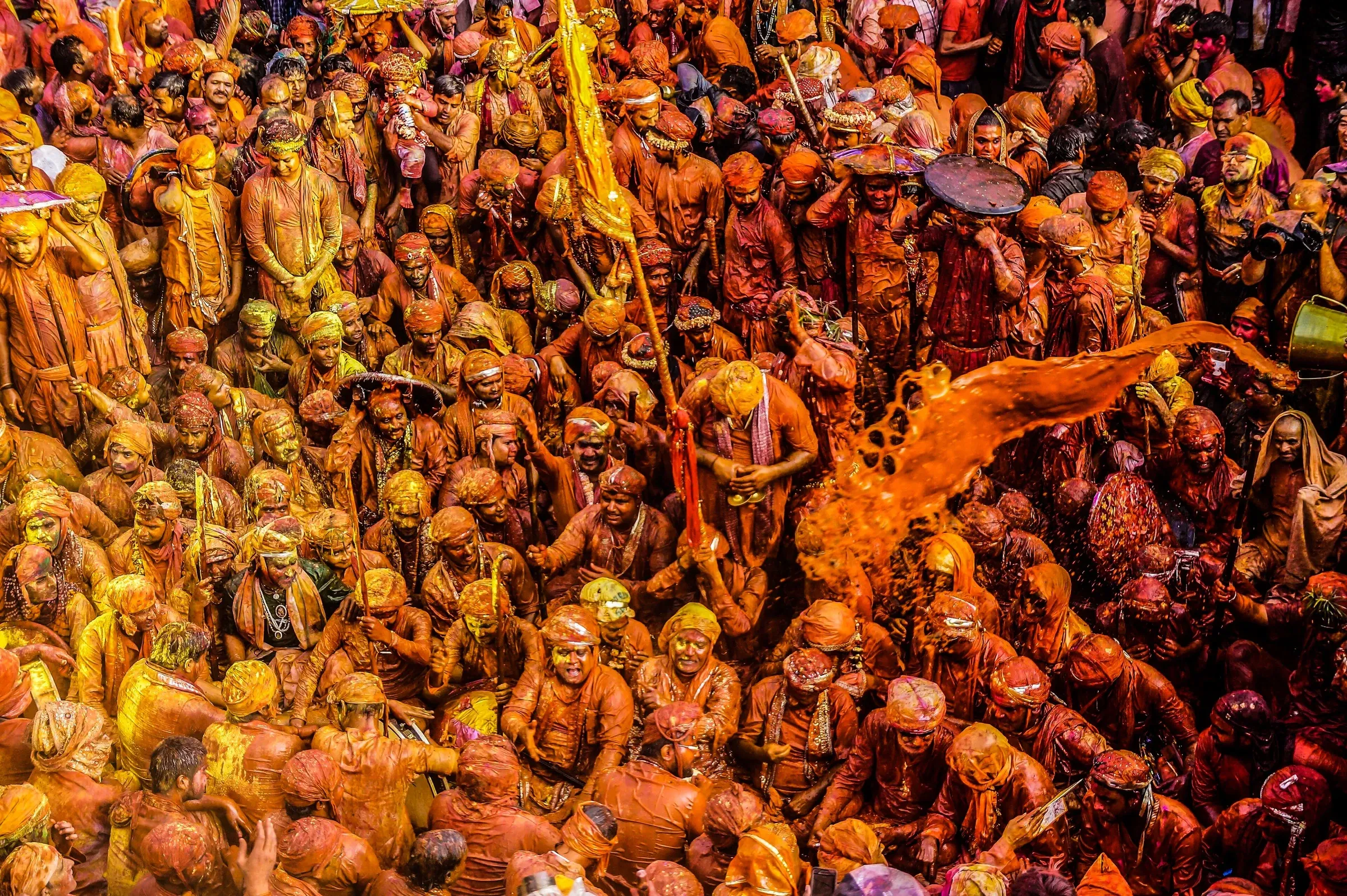 Crowds covered in orange and pink Holi colour during the festival in Mathura, Uttar Pradesh