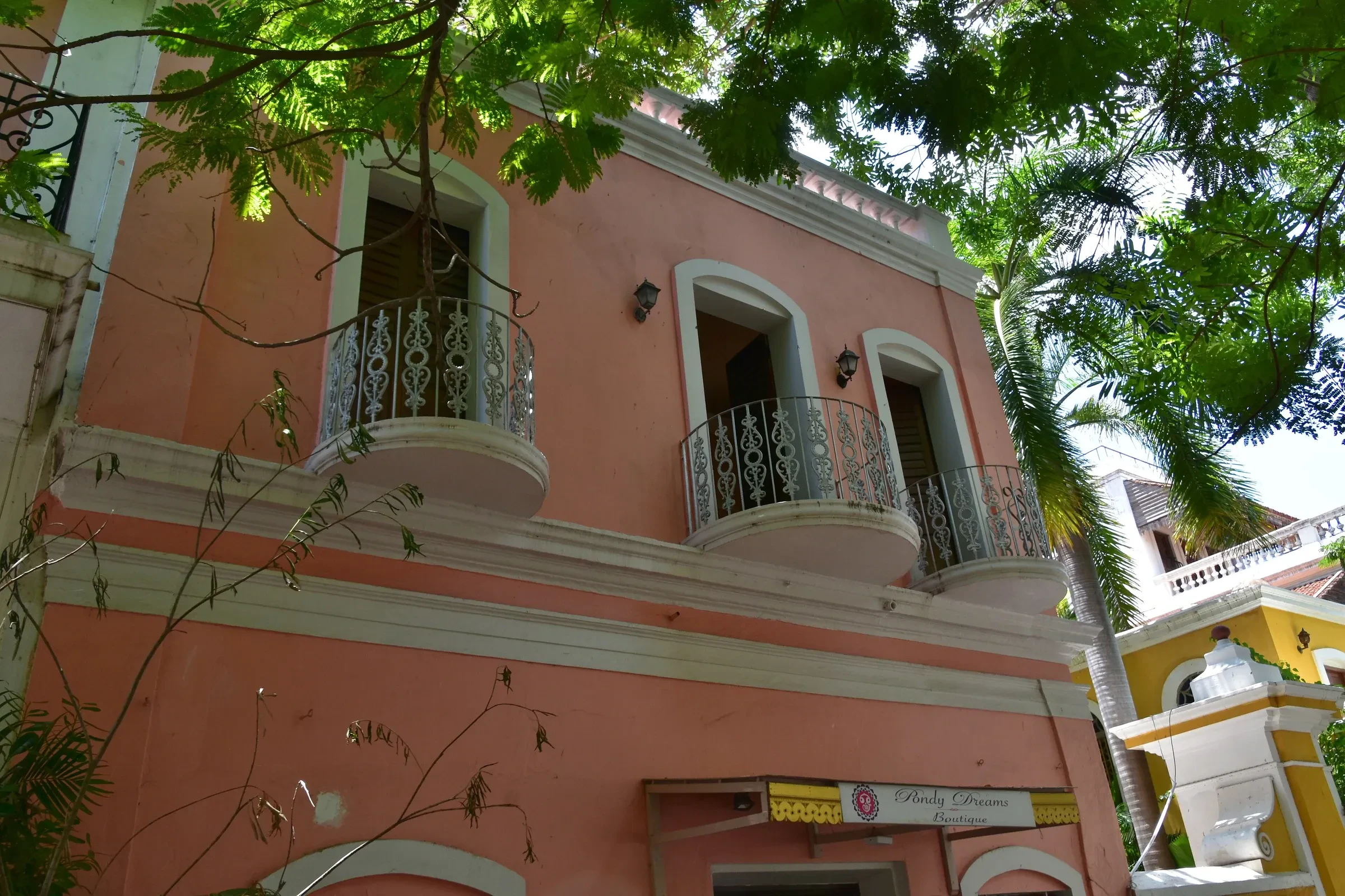 A pink colonial building with arched balconies in the French Quarter of Pondicherry