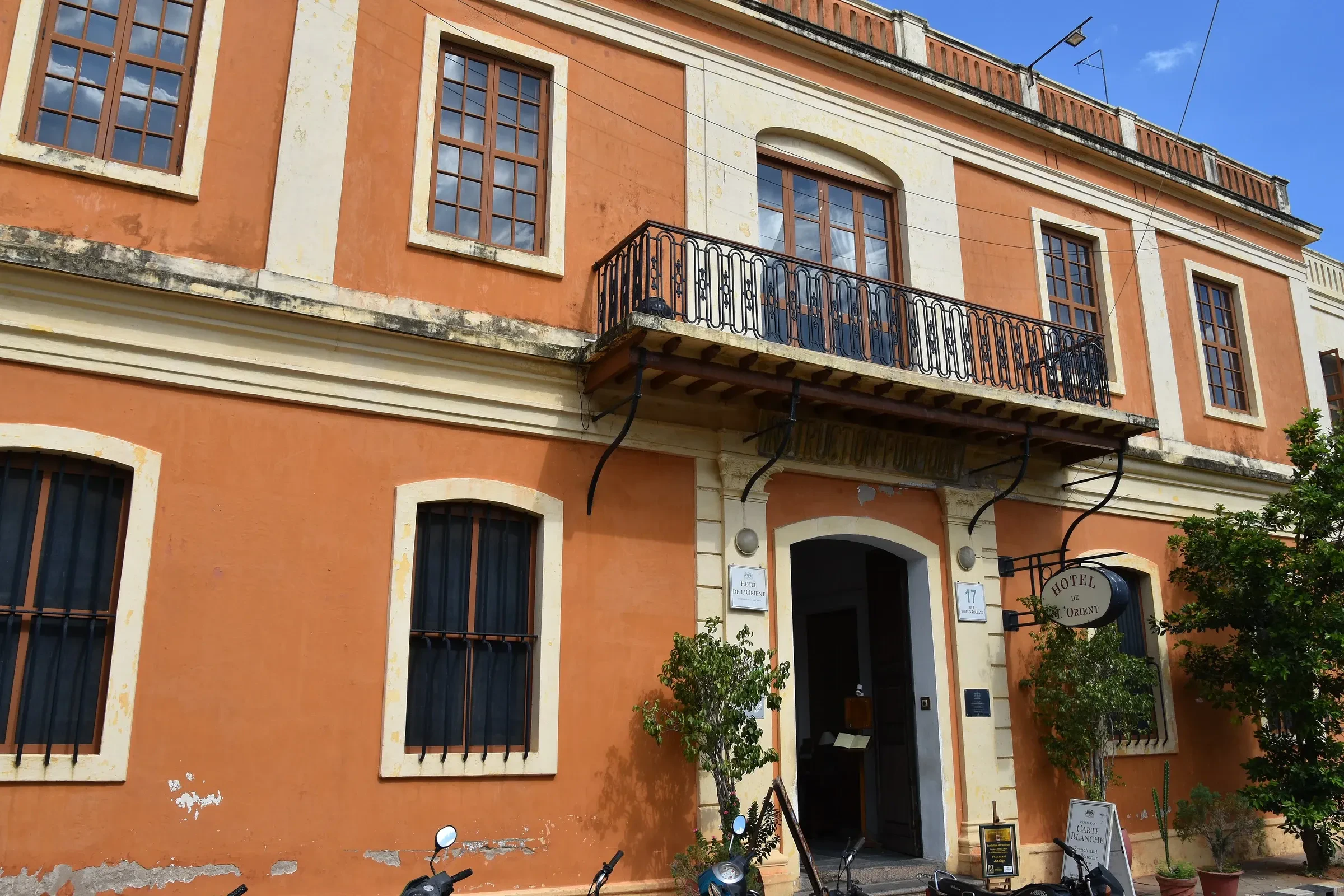 An ochre colonial townhouse with a wrought-iron balcony in Pondicherry's French Quarter